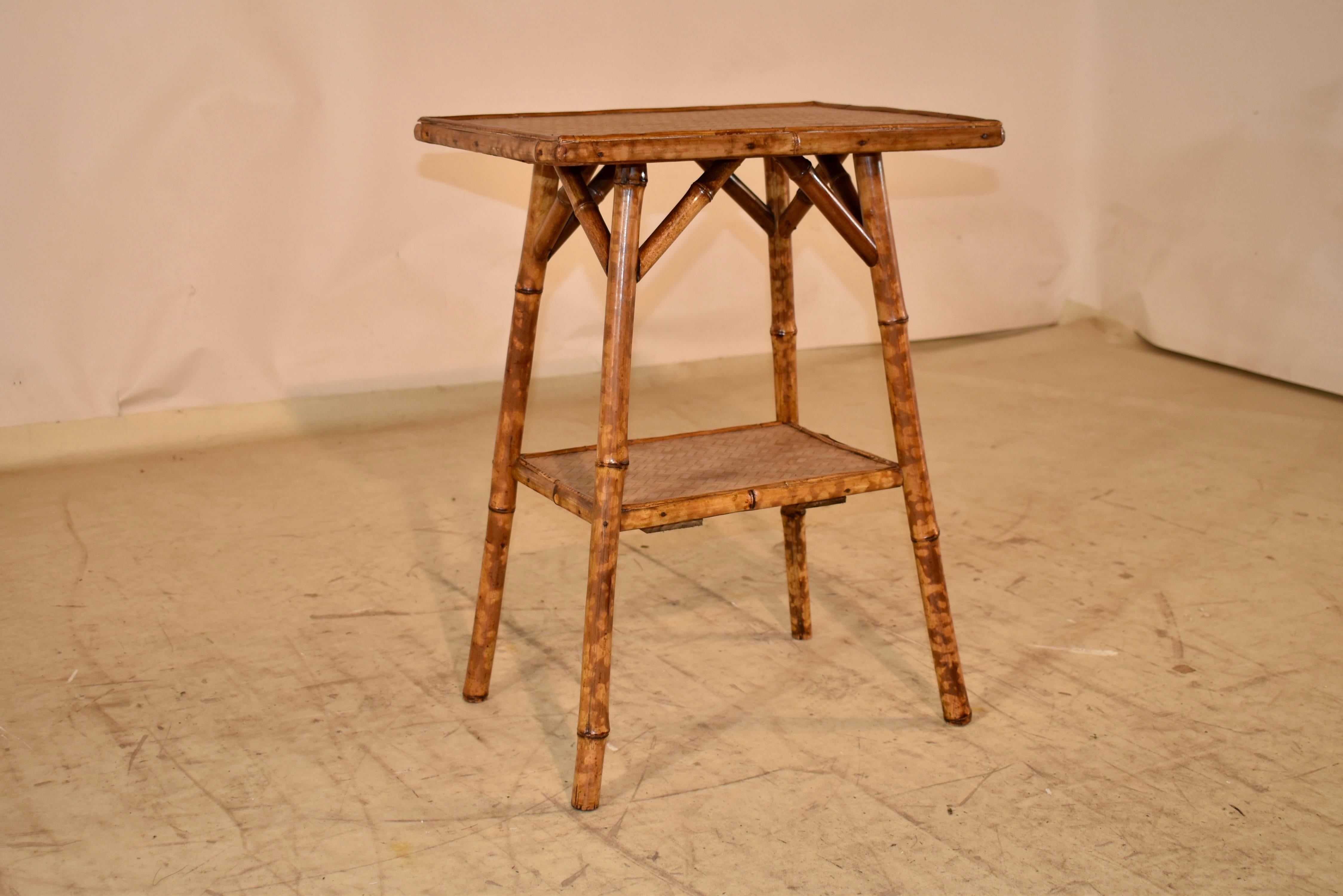 19th century tortoise bamboo side table from France.  The top and lower shelf are covered with herringbone textile for added design detail.  The top is supported on splayed legs, which are connected by a lower shelf.  These are wonderful side tables