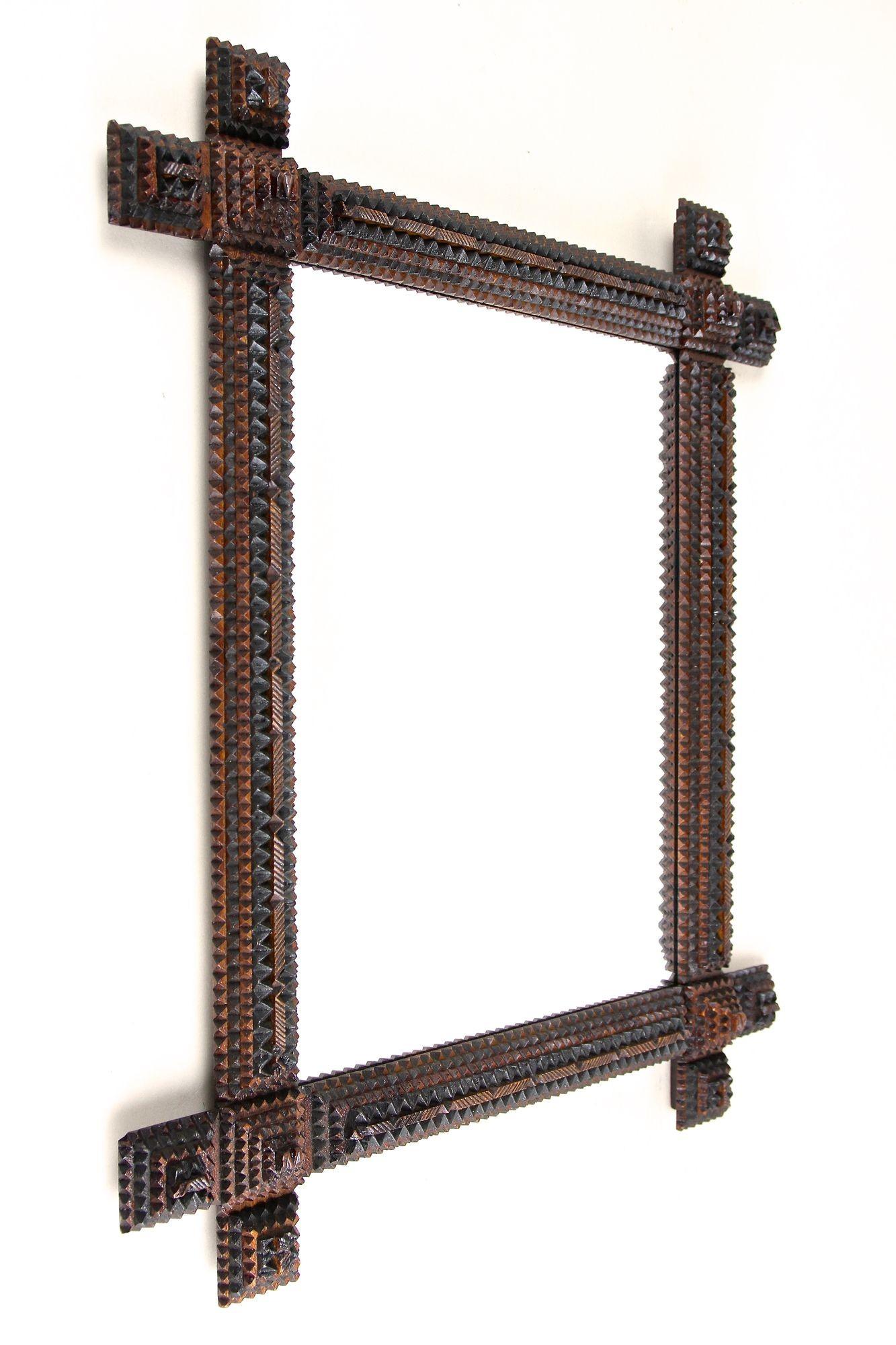 Specchio da parete Tramp Art rustico, assolutamente eccezionale, risalente alla fine del XIX secolo, intorno al 1880, in Austria. Questo particolarissimo specchio da parete rurale realizzato a mano colpisce per l'incredibile varietà di elementi: