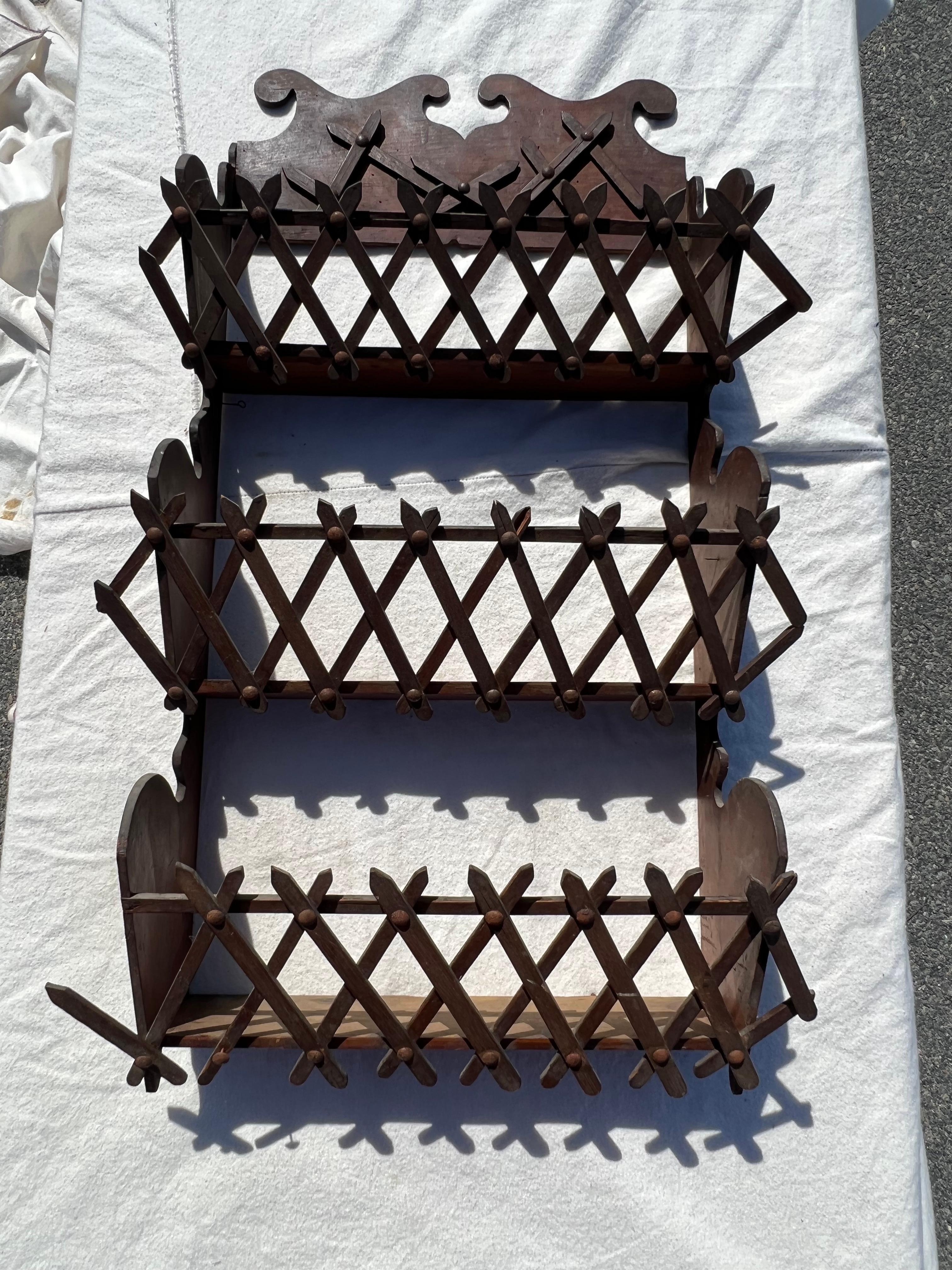 19th Century Tramp Art wall hanging rack with carved crossed sticks and carved rosettes on one side.