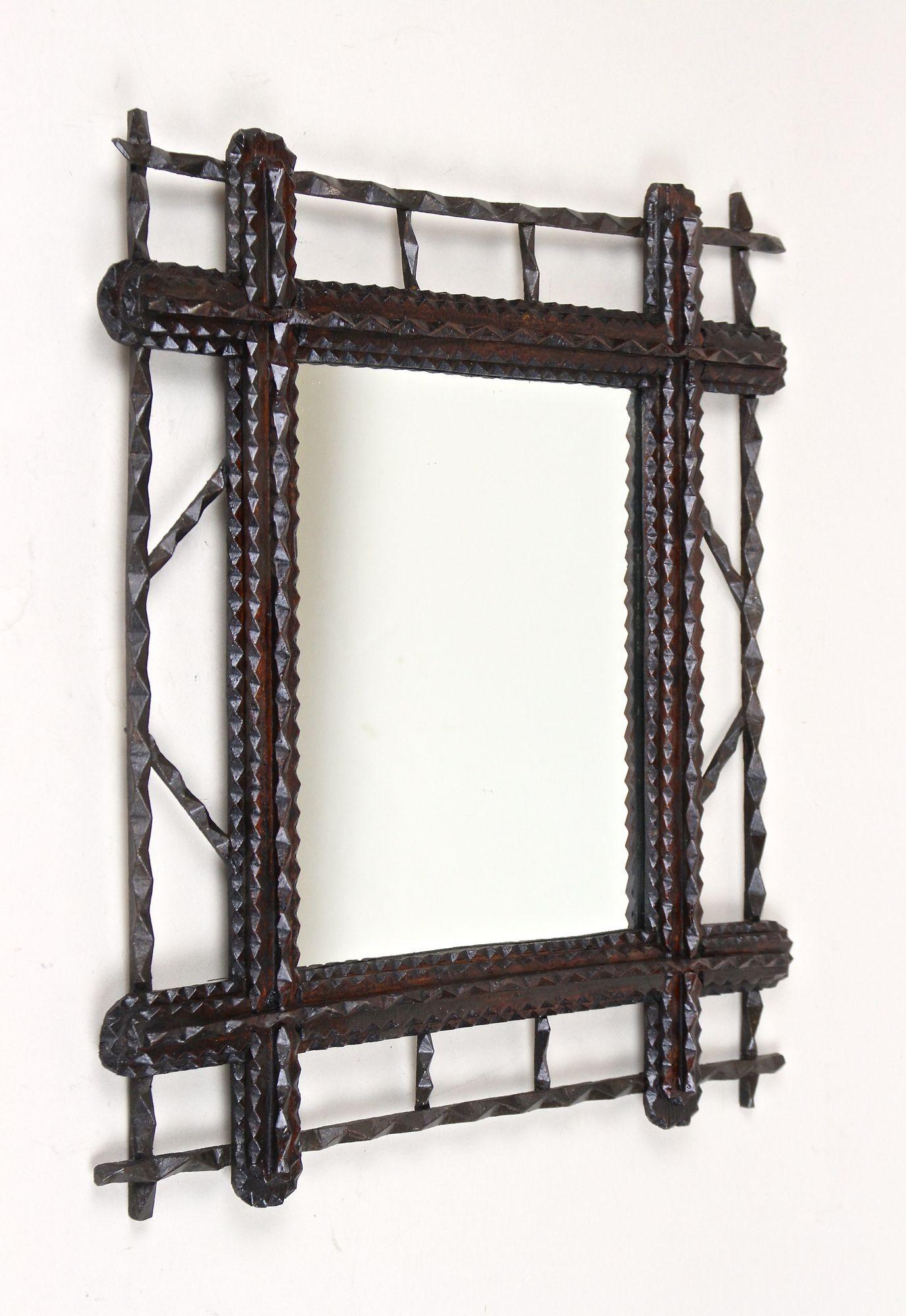 One of a kind Tramp Art Wall Mirror from the mid 19th century in Austria. Artfully handcrafted around 1860, this extraordinary rustic mirror has been effortfully carved out of basswood and comes in great original condition with a dark brown stained
