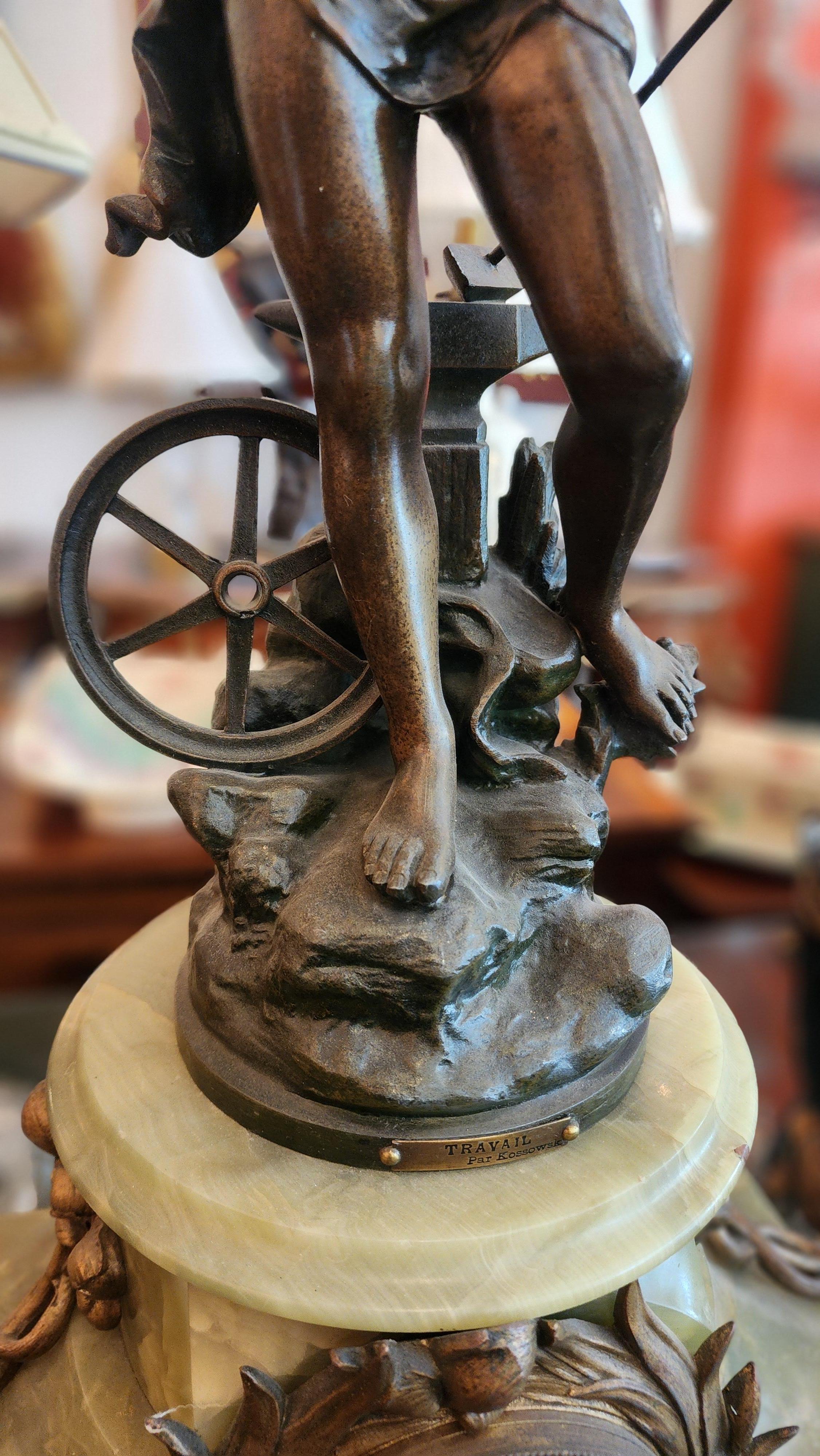 Elegante horloge ancienne fabriquée à partir d'une base en marbre vert, ornée d'accents floraux et feuillus en laiton dans le style rococo. Au centre, le cadran de l'horloge présente des chiffres romains et de fins détails noirs. Statue en bronze