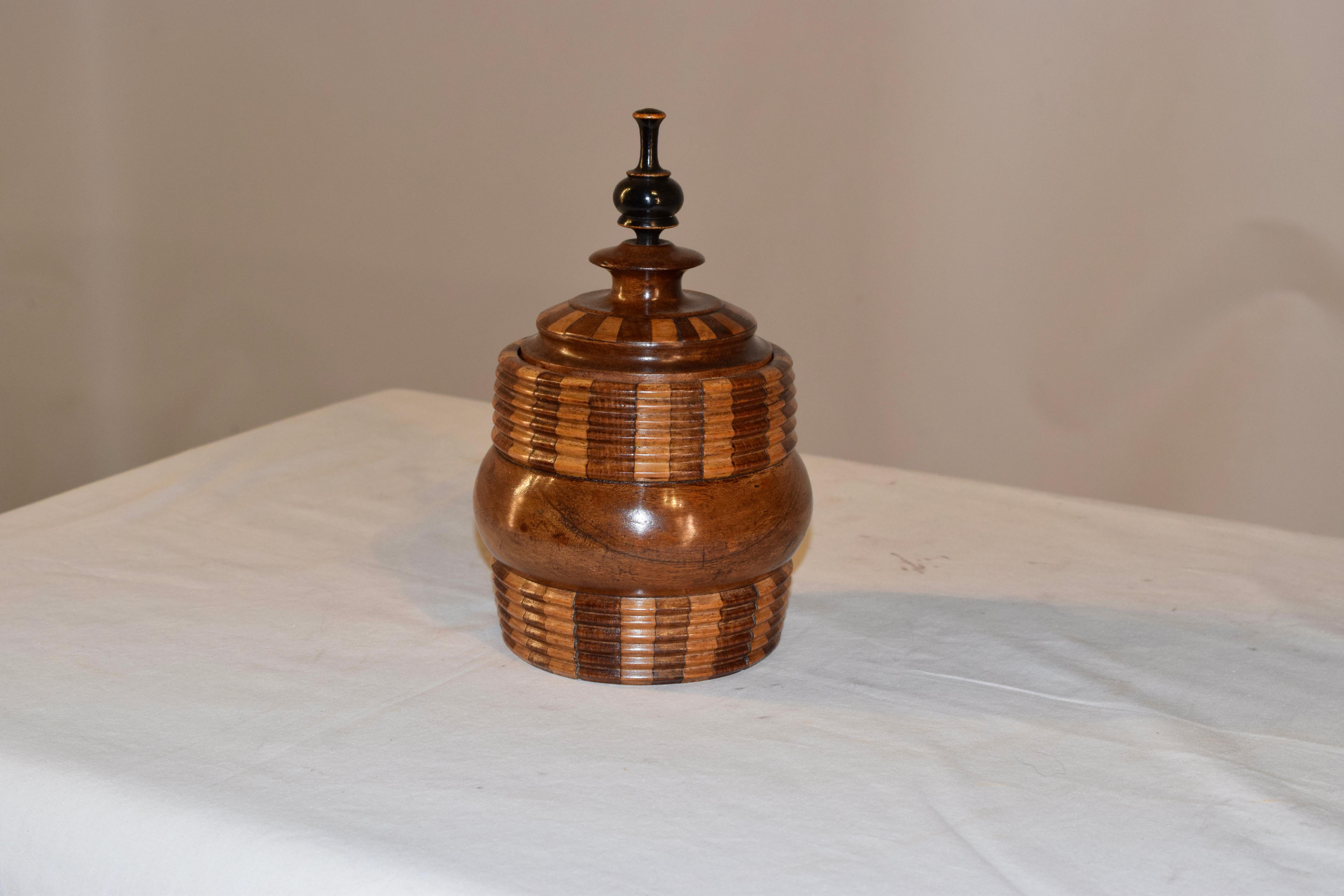 19th century lidded treen jar from Europe made from oak and fruitwood. The top has a hand-turned finial atop a lovely hand-turned shaped jar made from two different woods for a lovely color contrast. There are hand turned reeded collars on the top
