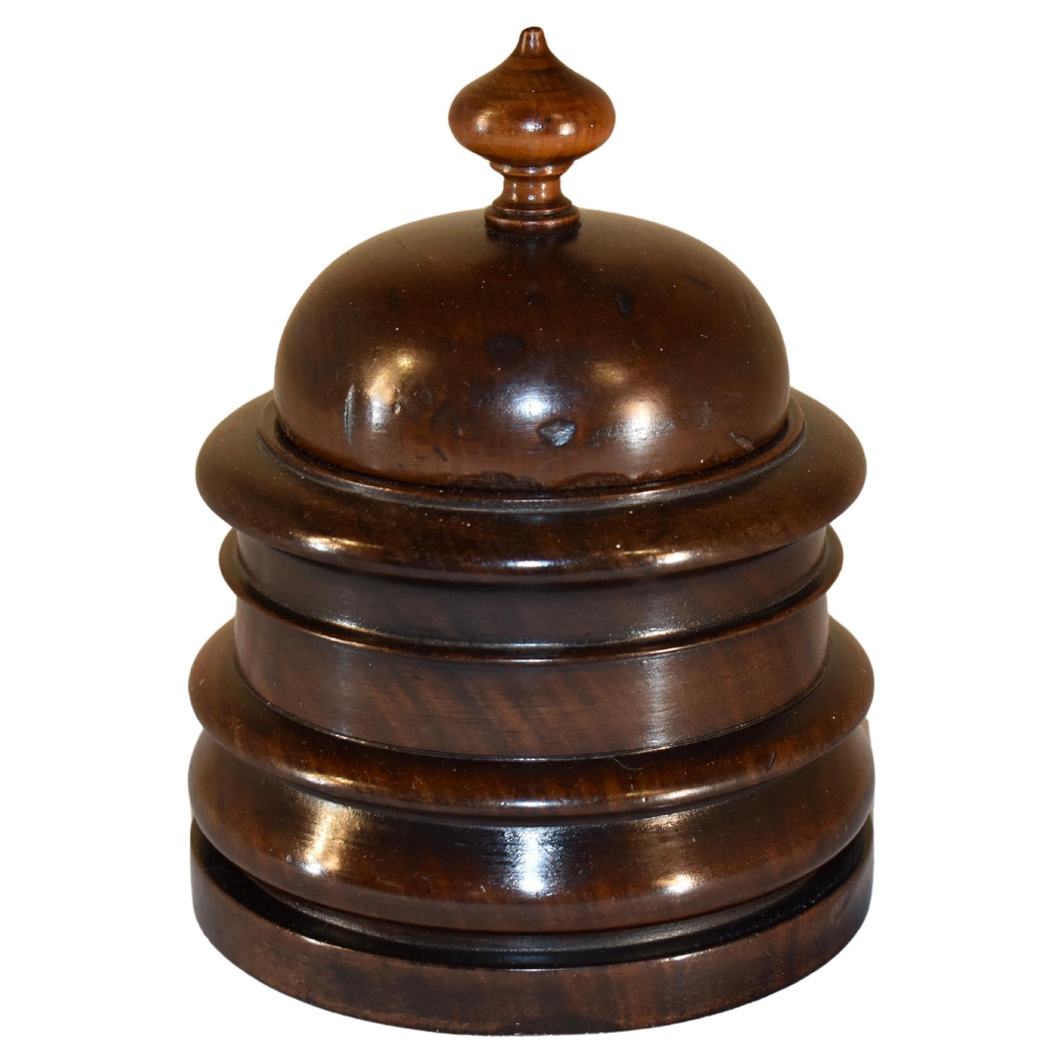 19th century turned treen lidded box made from mahogany.  This piece was expertly hand turned in England and has a lovely finial over a domed top, which rests on a shapely hand turned box..  This box may have been used for tobacco when it was made,