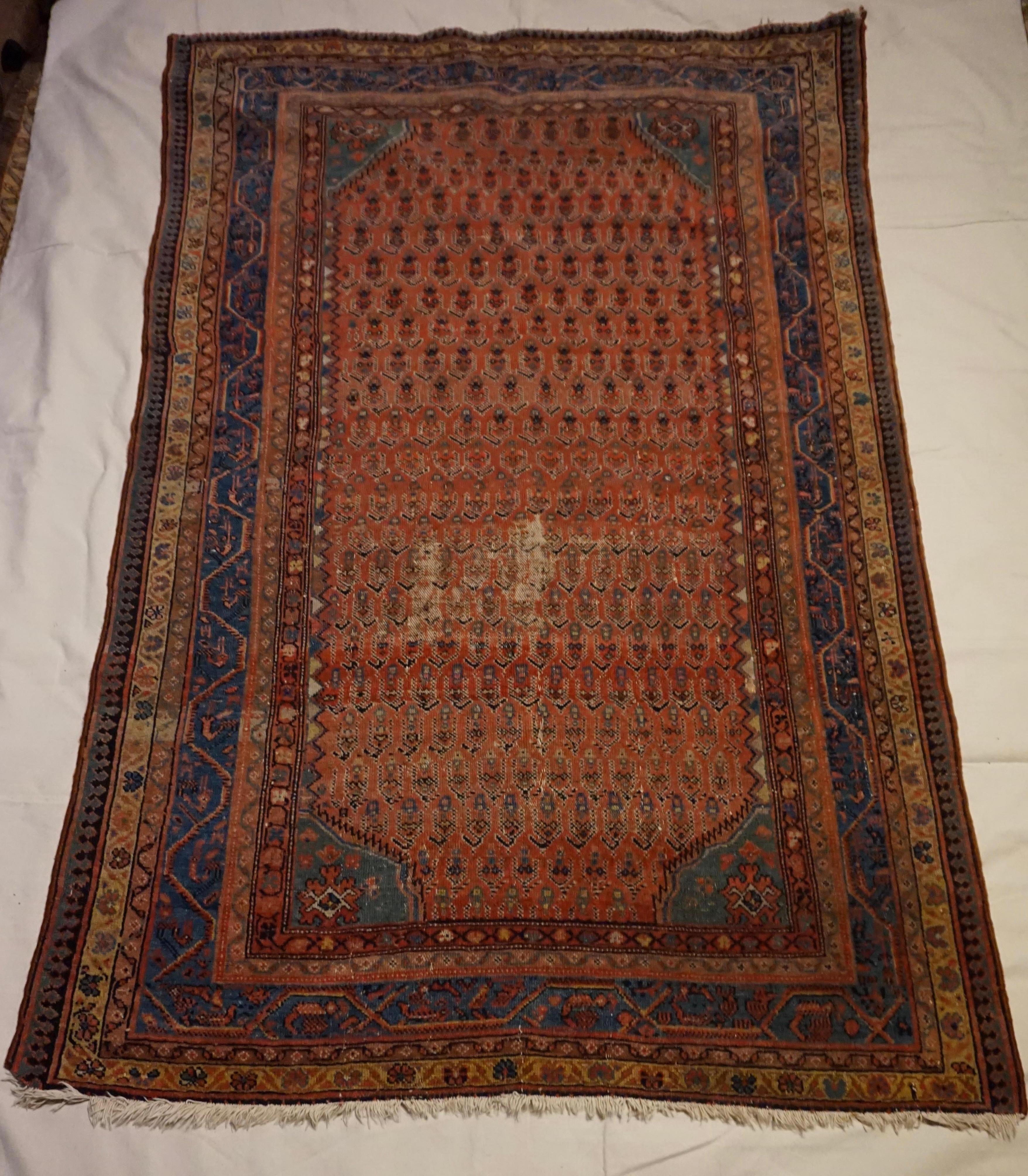 19th Century low pile tribal rug with beautiful paisley pattern hand woven in natural dyes. Intact with some low pile areas consistent with age but still exudes warmth and bygone splendour. Collectible and authentic rug in original condition.