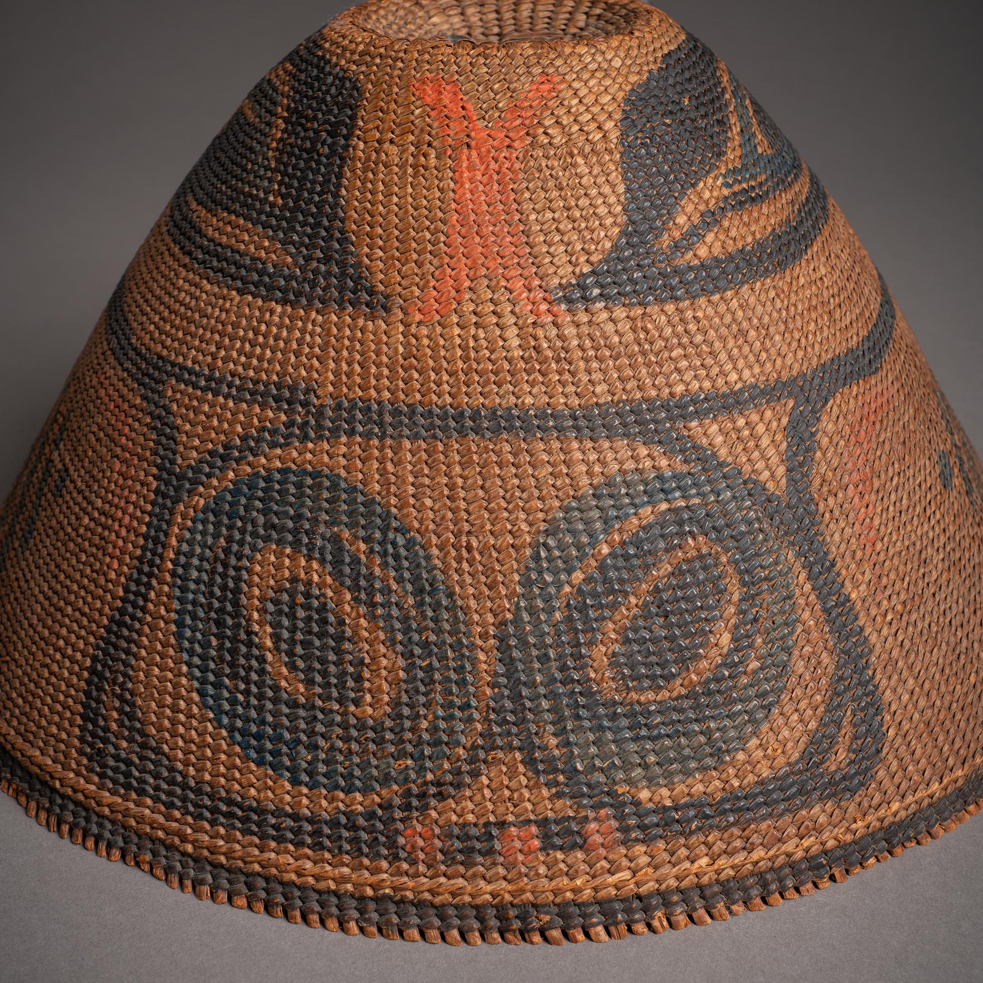 Peaked woven hats were commonly found among the Nuu Chah Nulth (Nootka) of the southern Northwest Coast of North America. Some, like this example, were flat-topped, while others terminated in a conical knob. They often bore iconography of animals