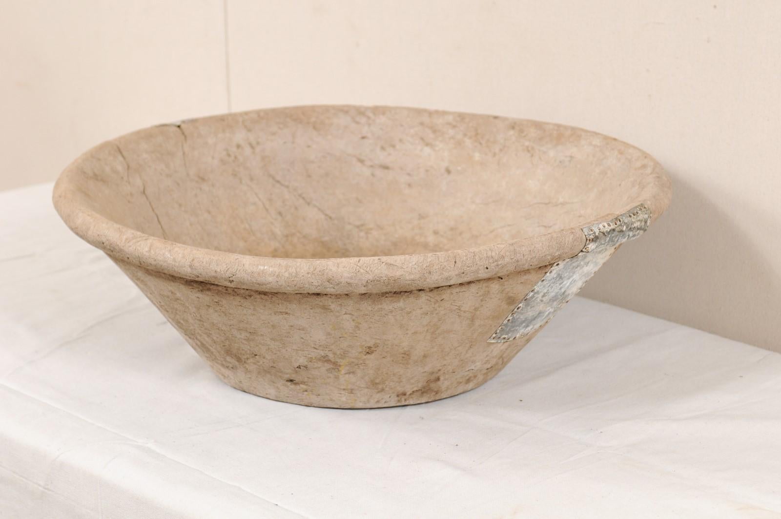 A Turkish burl wood dough bowl from the 19th century. This antique bowl from Turkey has been hand carved from wood and has fabulous old metal repairs in three areas about it's exterior. This round-shaped bowl, handcrafted from burl wood, has a