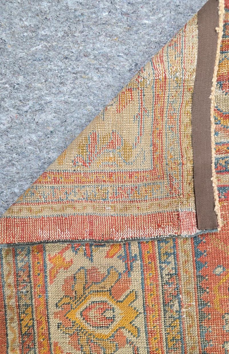 Porta un tocco di arte anatolica senza tempo nella tua casa con questo antico tappeto turco Oushak, un pezzo raro e squisito che risale alla fine del XIX secolo. Questo tappeto, che misura 9 x 12,8 piedi, presenta un sorprendente campo verde cielo