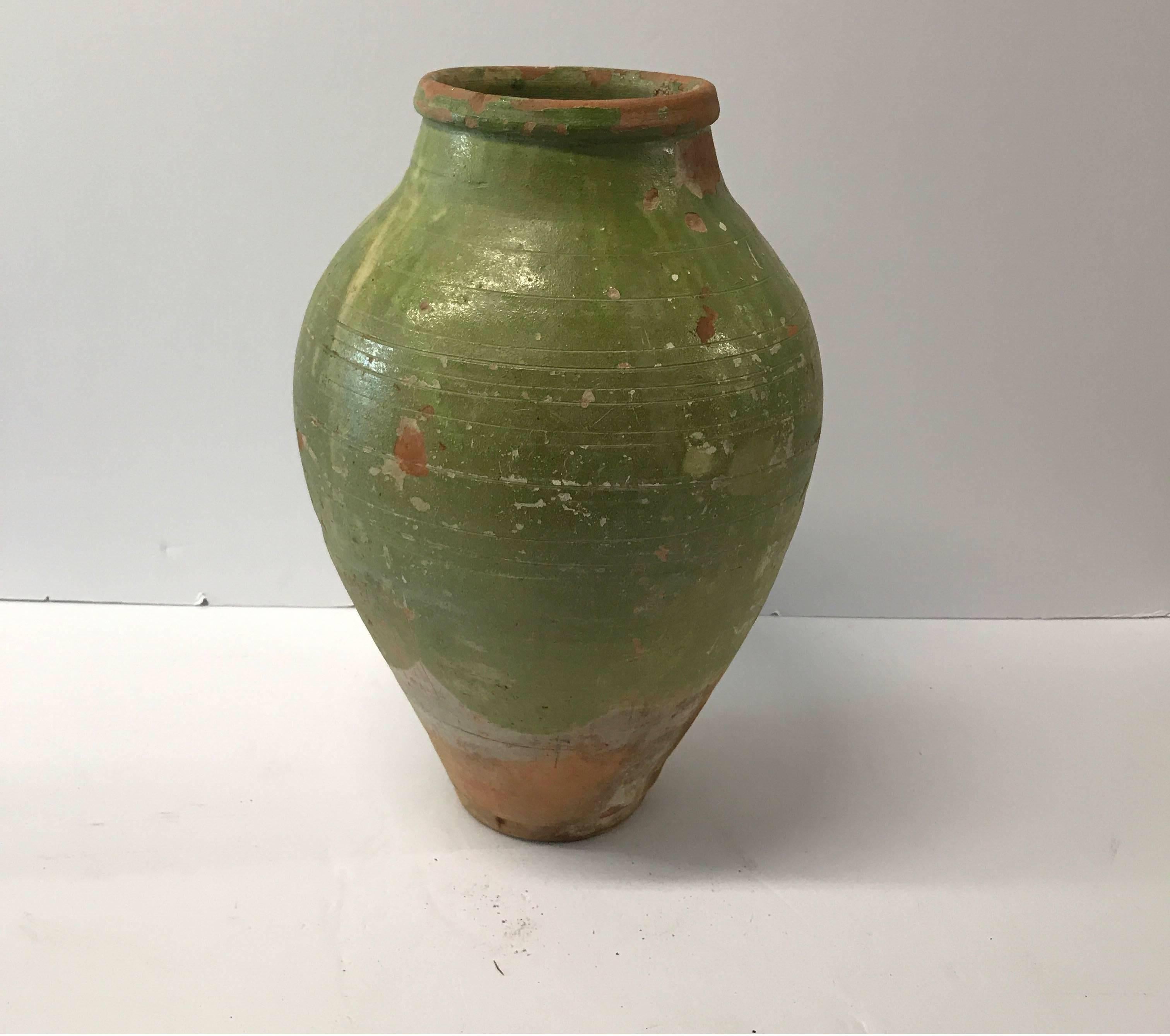 19th century Turkish terra cotta oil jar with green glaze 



Dimensions: 16.25 in H x 10.5 in diameter with a 5.75 in diameter opening and a 4.5 in base diameter.