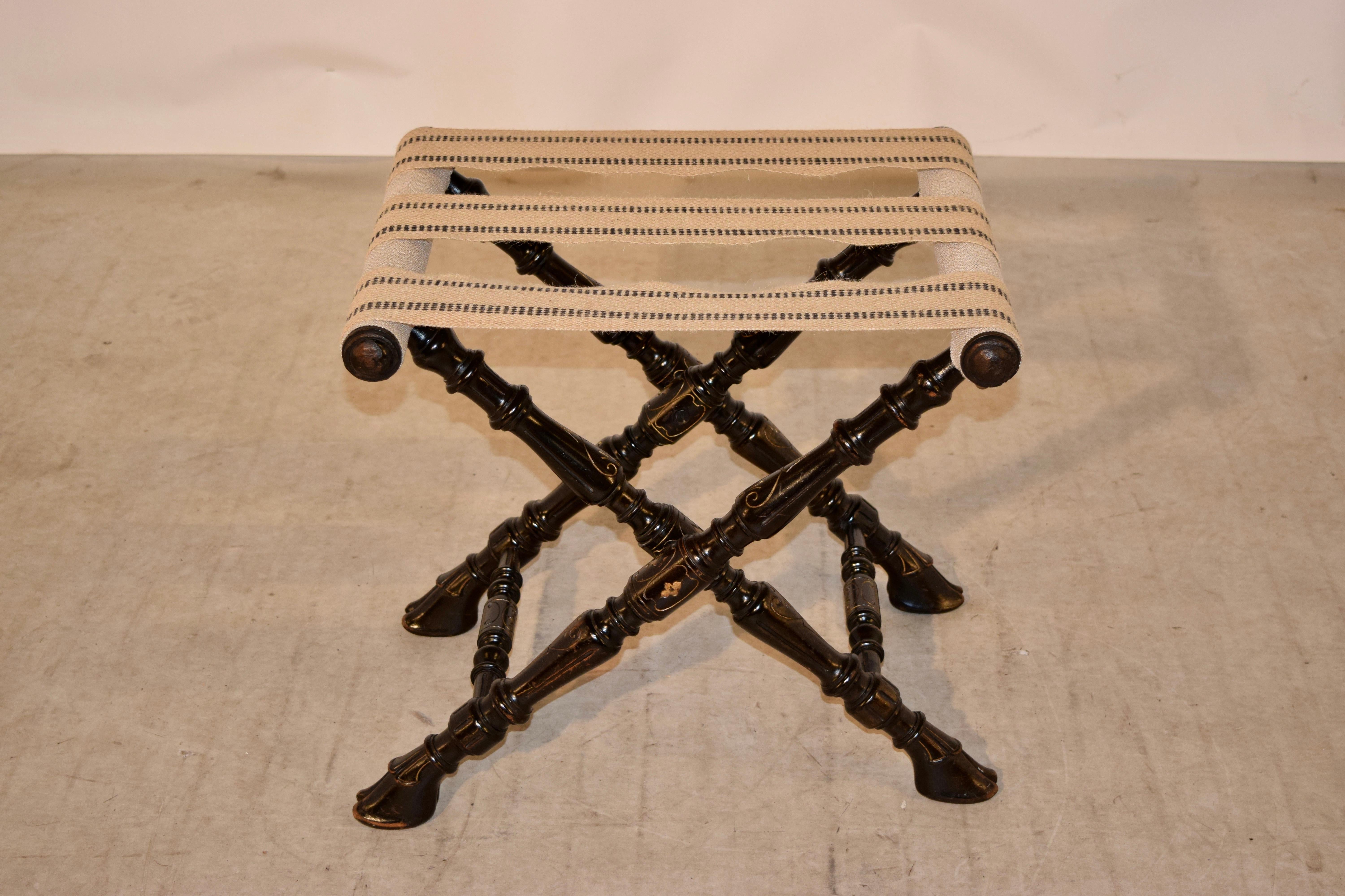 19th century turned folding luggage stand from England made from fruitwood and painted black with hand-painted gold accents. The frame is hand-turned and end in hoof shaped feet. Lovely form and function.