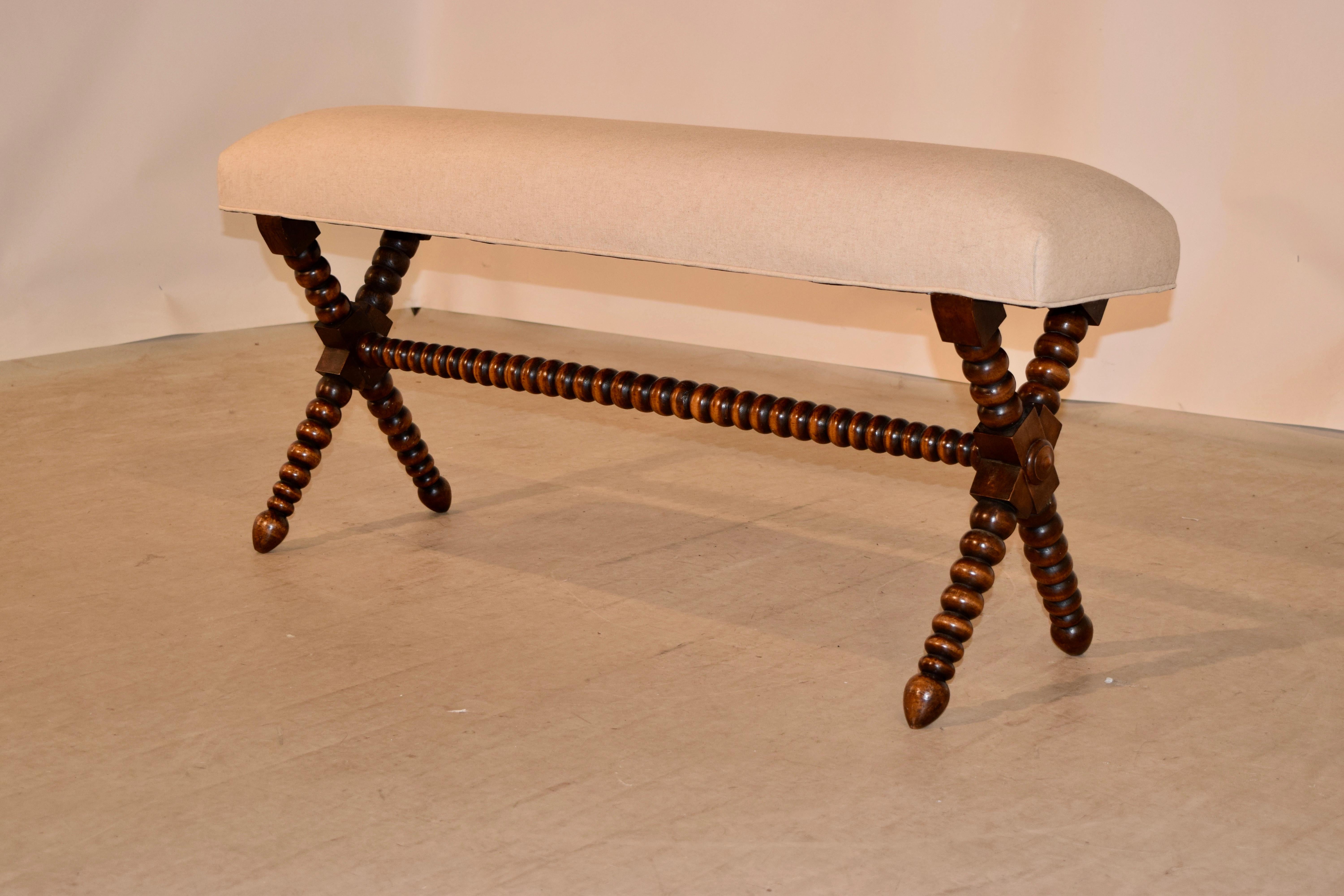 19th century mahogany bench from France with a newly upholstered linen seat supported on a frame with hand turned x-stretcher legs. Seat measures 11.25 inches deep.