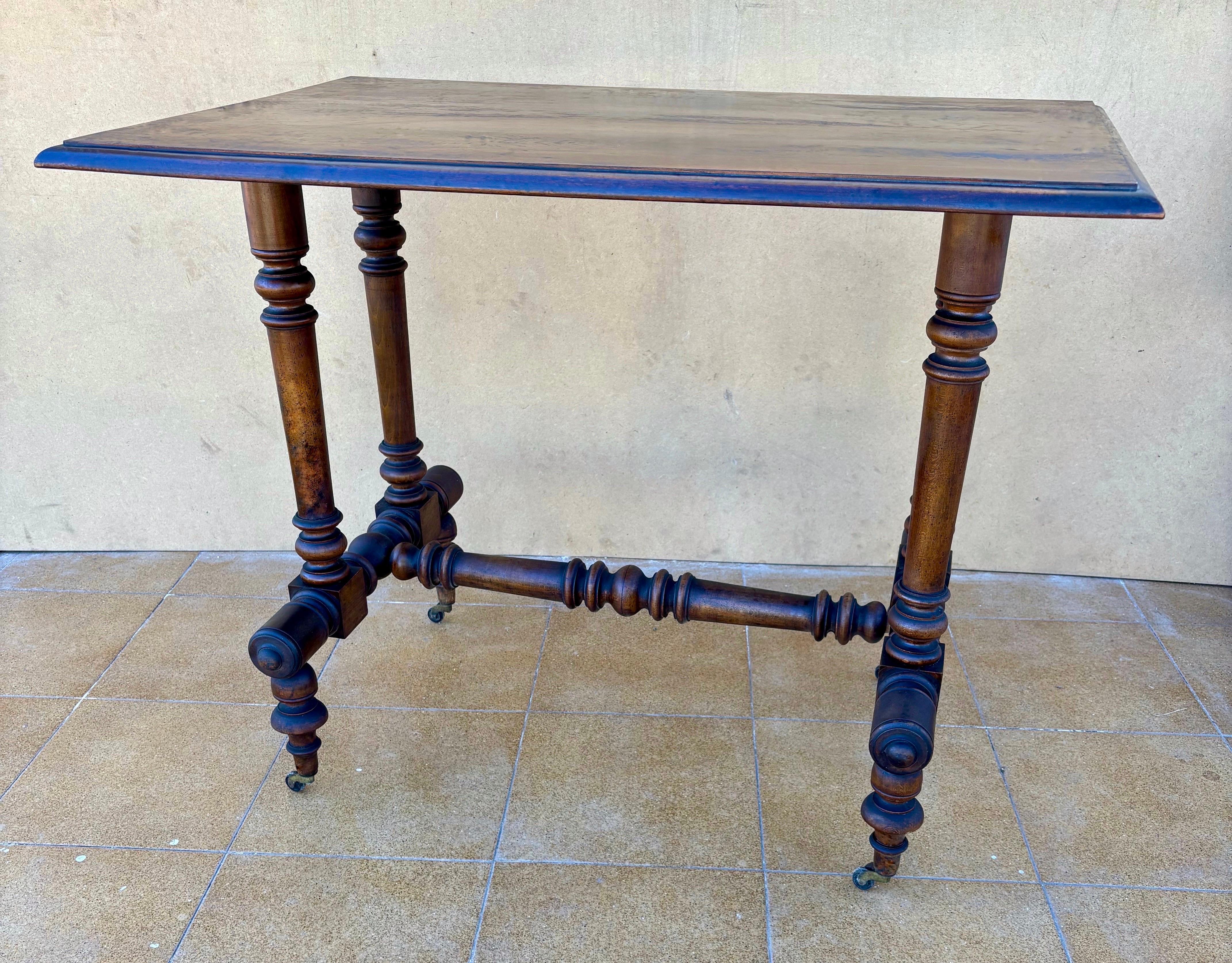Elegante mesa auxiliar del siglo XIX con una hermosa base de patas torneadas y ruedas originales, típicas de la artesanía victoriana tardía. La pieza presenta un intrincado diseño de camilla con múltiples elementos torneados, que añaden carácter