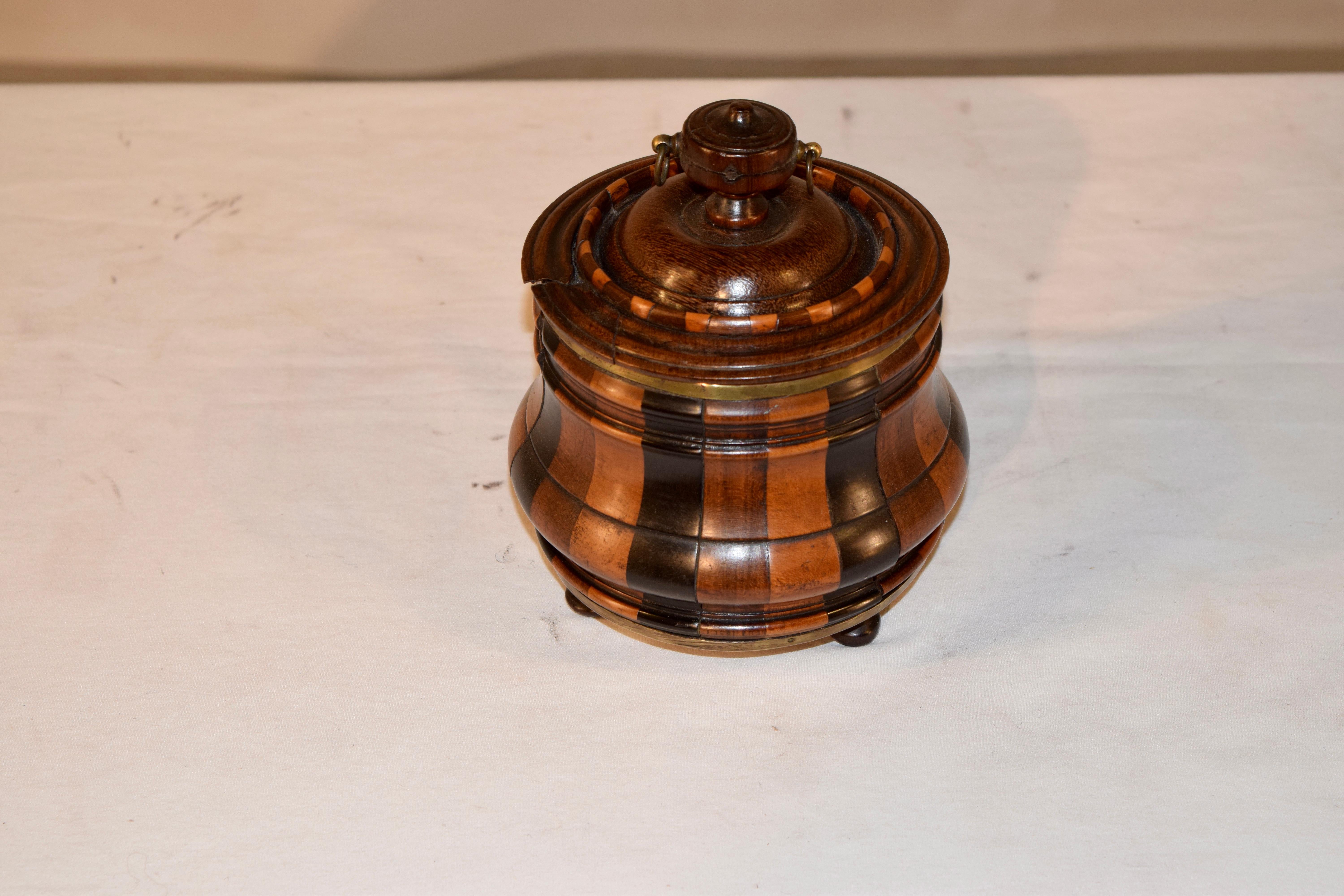 19th century turned treen lidded jar with a hand turned top which is adorned with a hand turned finial and striped banding, over staves made from three different types of wood, banded together with handmade brass bands. The jar retains its original