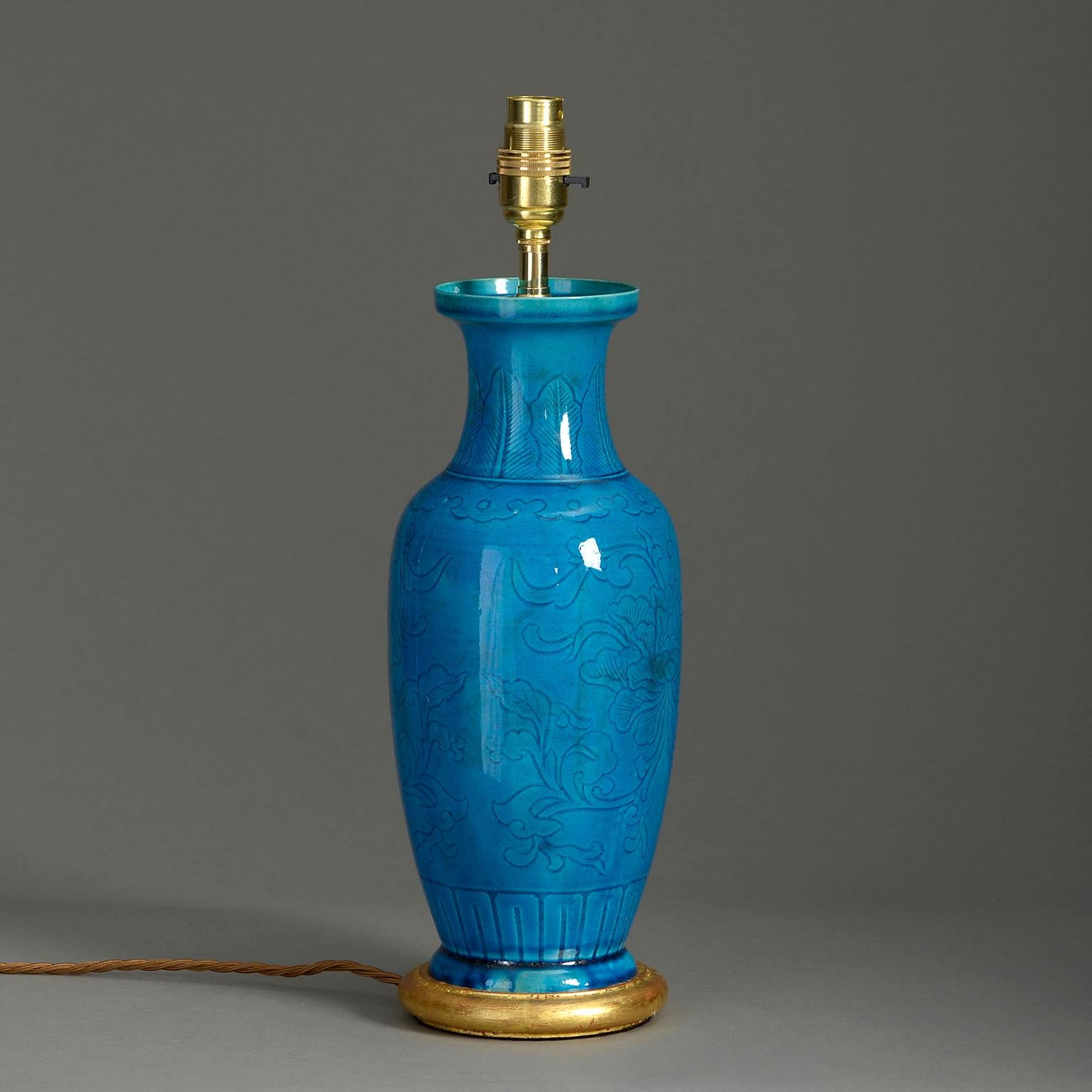 A nineteenth century baluster vase of medium scale with rich turquoise glaze, the body with incised decoration. Now mounted on a hand-turned water gilded base.

Dimensions refer to vase and base.

Shade not included.

This vase lamp with its
