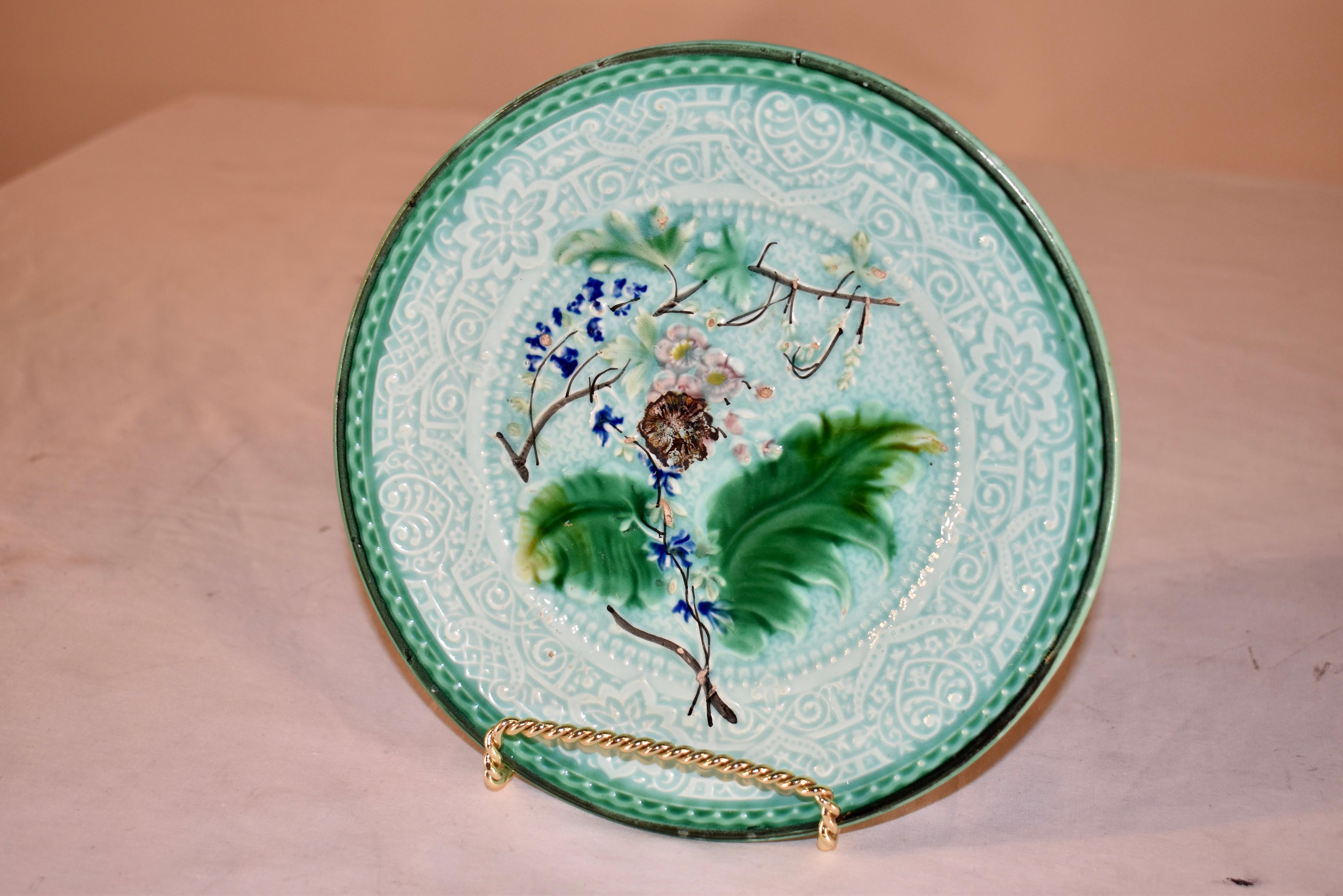 Assiette en majolique de la fin du 19e siècle, d'une belle couleur de fond turquoise pâle, bordée d'un vert luxuriant.  Le centre de l'assiette présente un motif global pressé, qui a presque l'apparence d'une dentelle, avec un motif central de