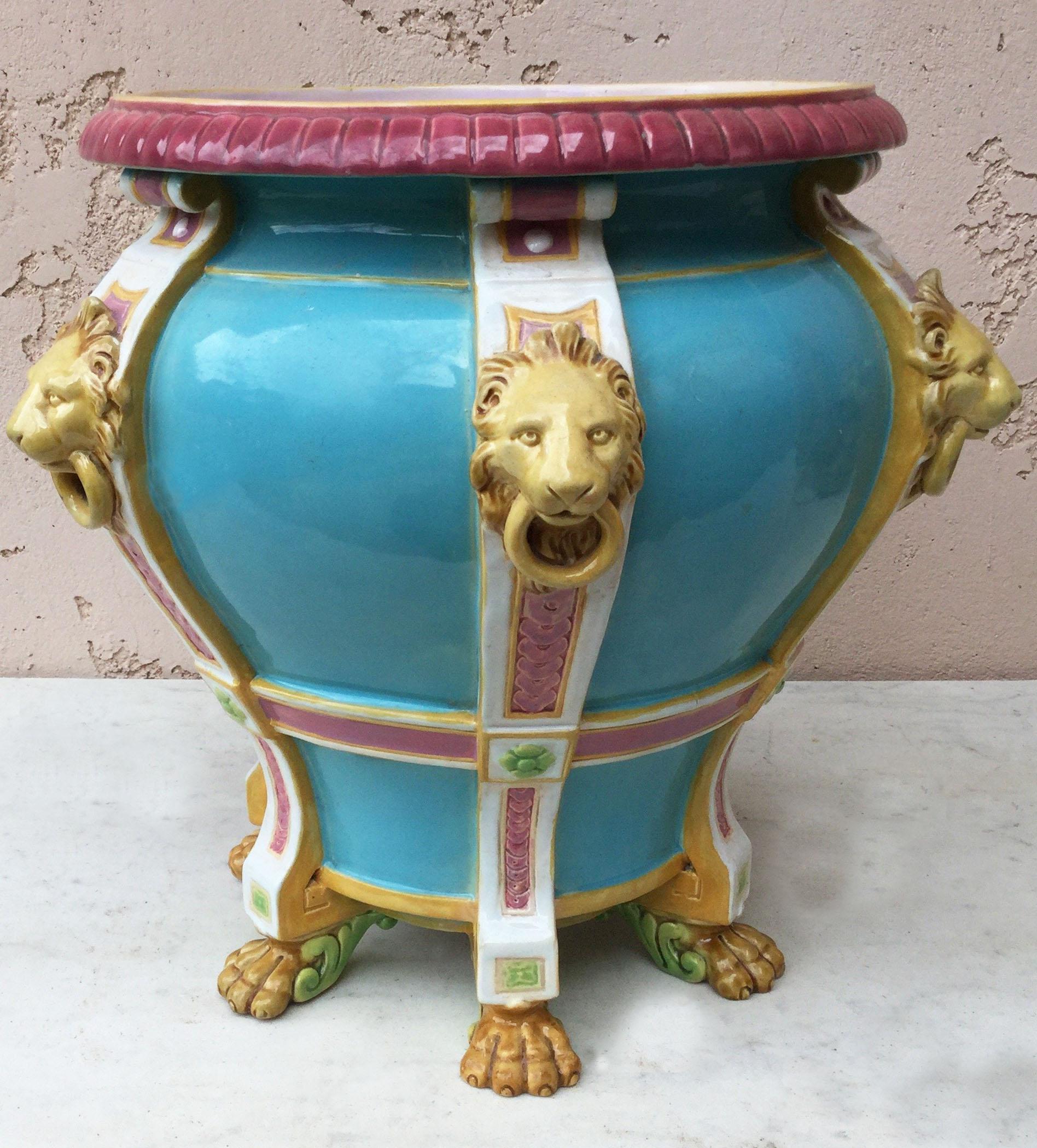 19th century aqua turquoise Minton jardiniere with six pilasters applied with lion mask and ring handles and stands on paw feet.