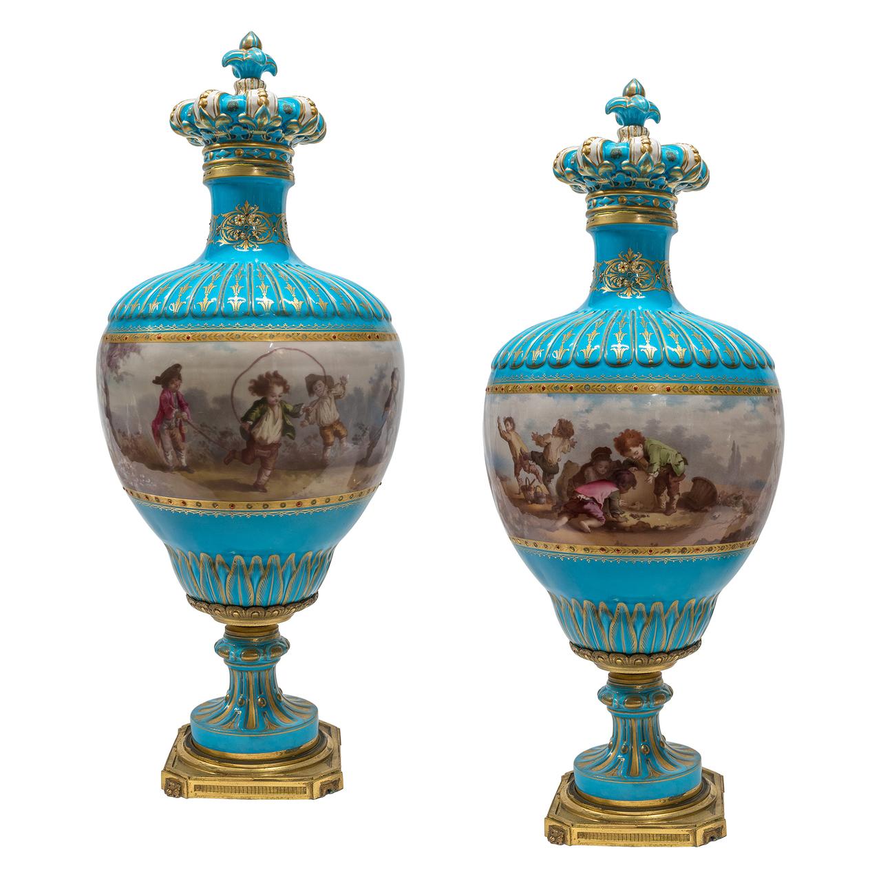 A high quality gilt bronze and Turquoise Sèvres style jeweled Porcelain clock set. The clock surmounted by a covered urn and flanked by lion masks on each side, en suite with a pair of painted turquoise porcelain vases and covers depicting playing.