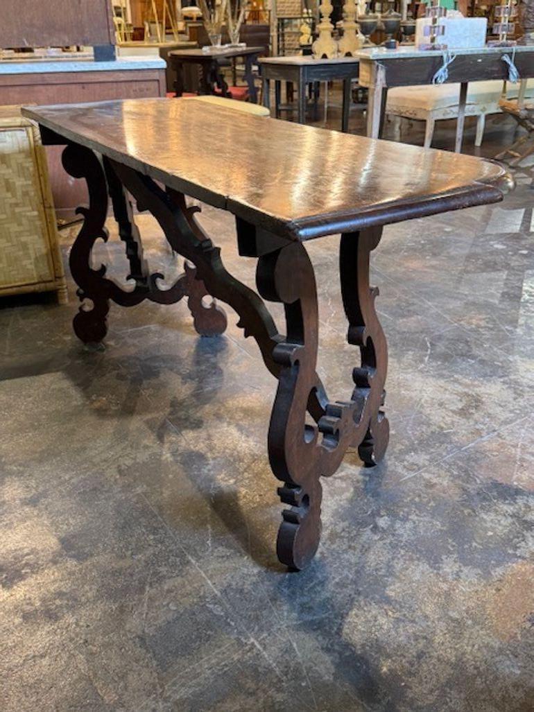 La Mesa Consola Toscana de Nogal Tallado del siglo XIX es un mueble elegante y con estilo, con una rica historia. La mesa presenta una base de pedestal bellamente tallada, que añade un toque de sofisticación a cualquier hogar. Hecha de robusta
