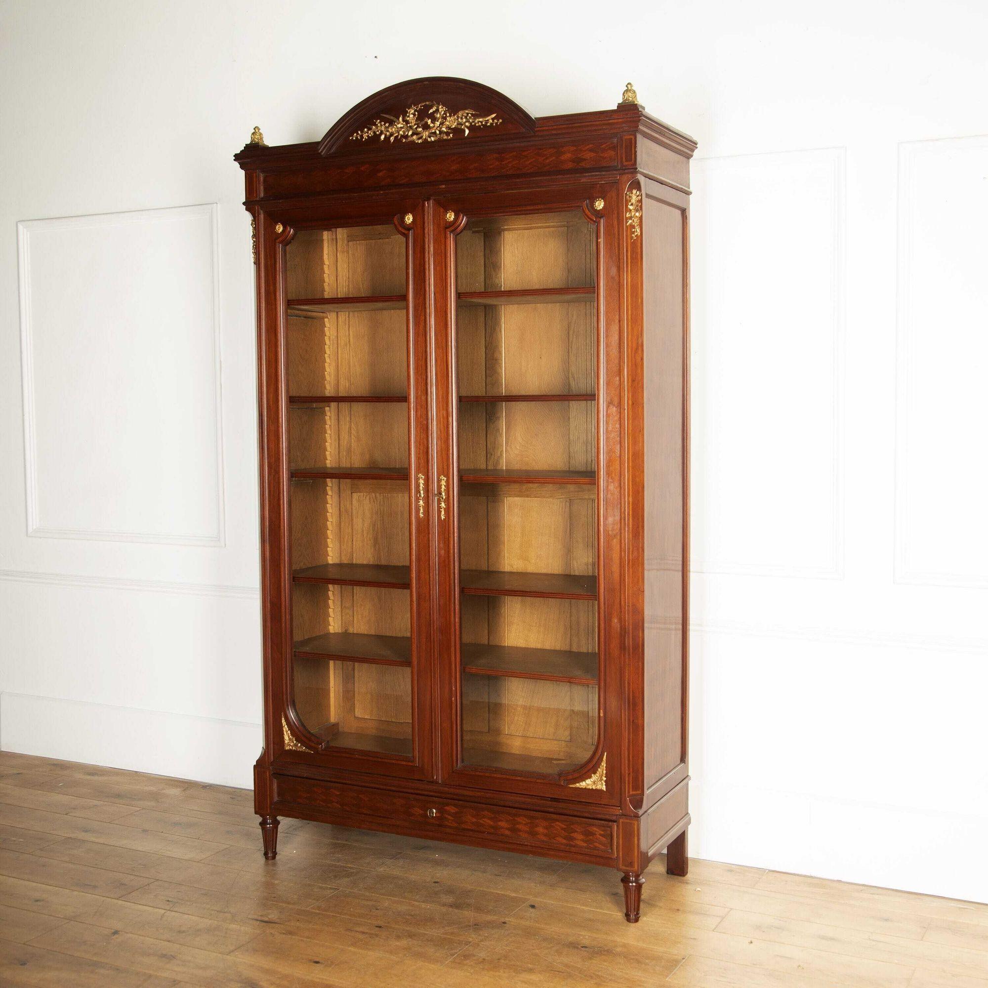 Wonderful late 19th Century two-door mahogany bookcase.
This bookcase is of very fine quality mahogany and has its original ormolu mounts. It has a lovely parquetry design to the side which is typical of 19th Century furniture. 
Has working locks