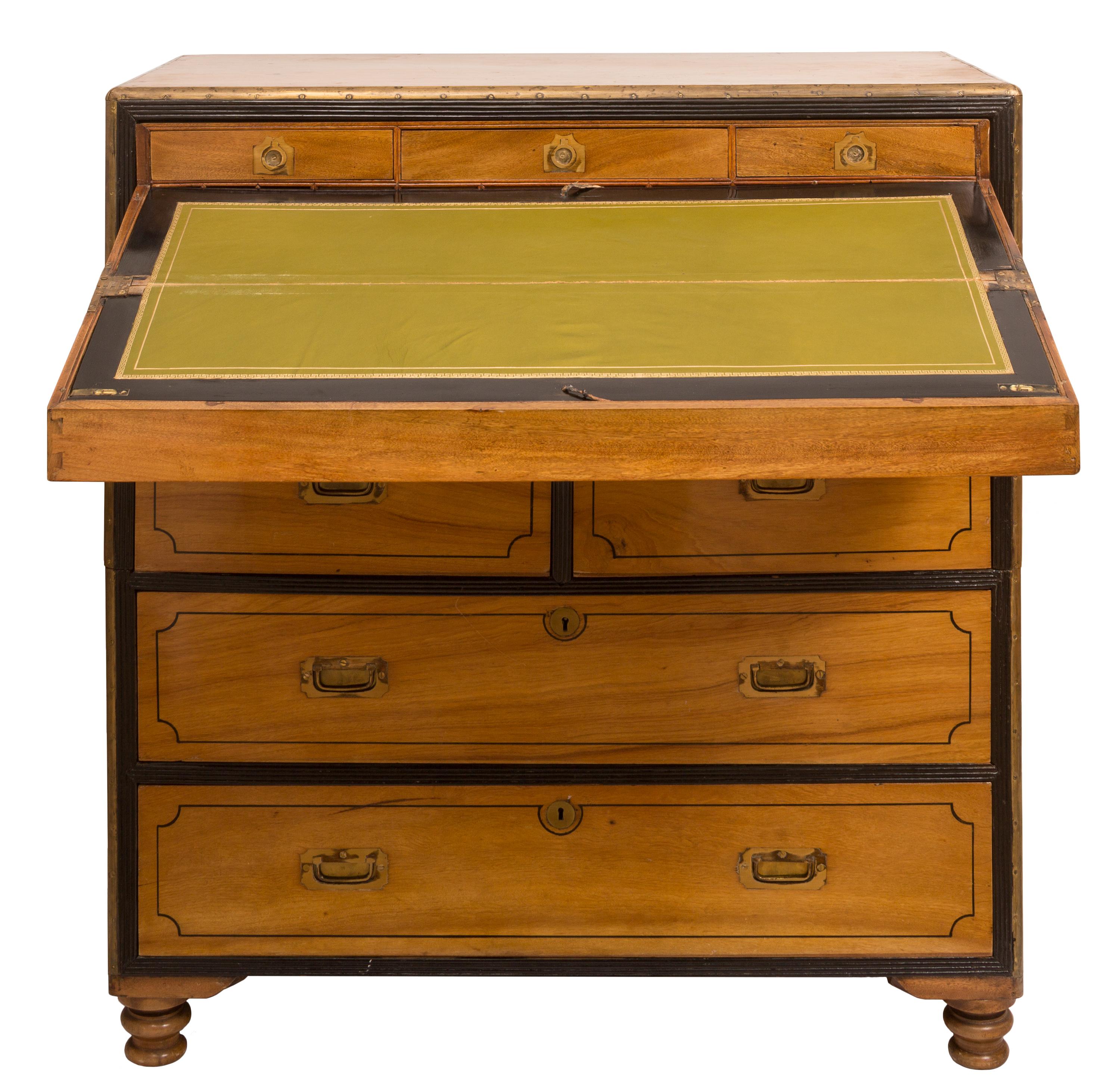 This 19th century camphor wood British military Campaign two-piece chest of drawers features a hidden fold-out writing desk. The attractive 