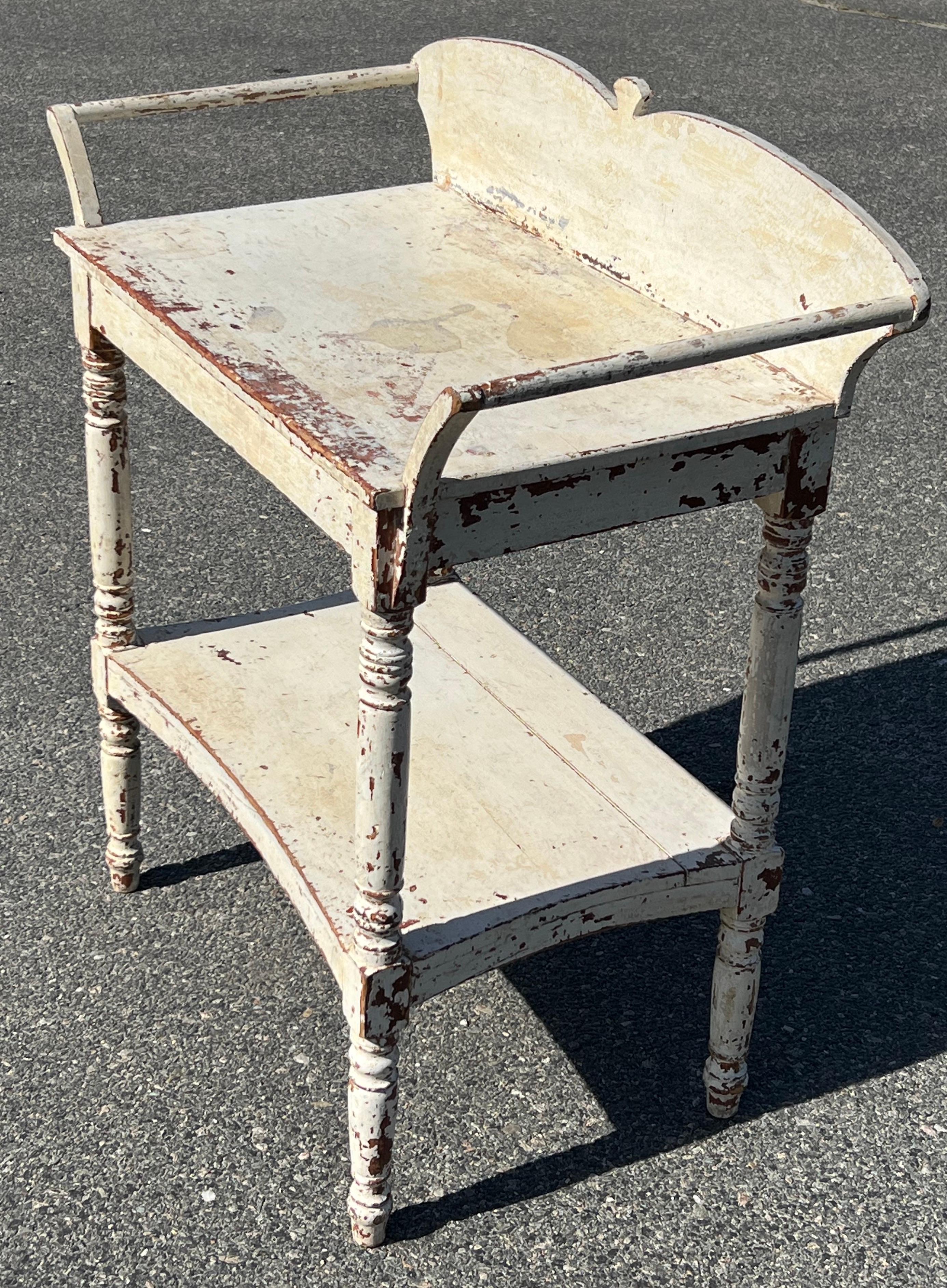 19th century Washstand with two tiers. Nicely shaped rear backsplash with spindles on either side. In original white paints, on turned legs. Surface height 29.25 inches.