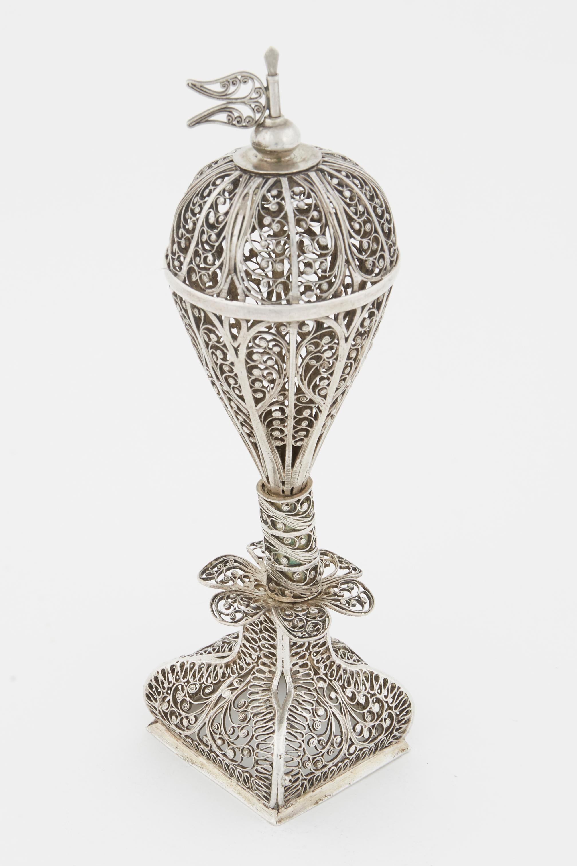 Handmade silver filigree spice tower, Zhytomyr, Ukraine, 19th century.
On a square filigree base. The stem is decorated with six petals that connect to pomander shaped upper portion and topped with filigree flag.
Marked with 