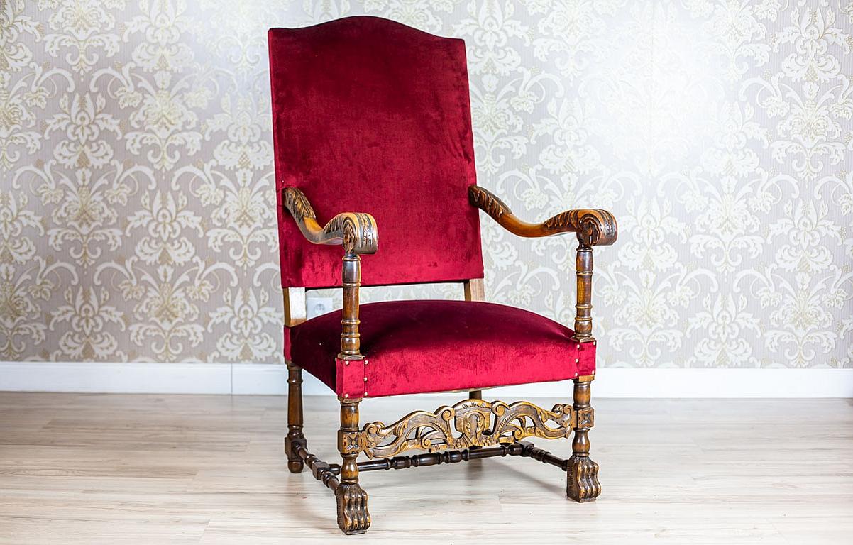 We present you a wooden throne-like armchair with a softly upholstered seat and a backrest.
The rails are finished with volutes.
Furthermore, the rounded legs are joined with a H-shaped stretcher.

This armchair has not undergone a renovation but it