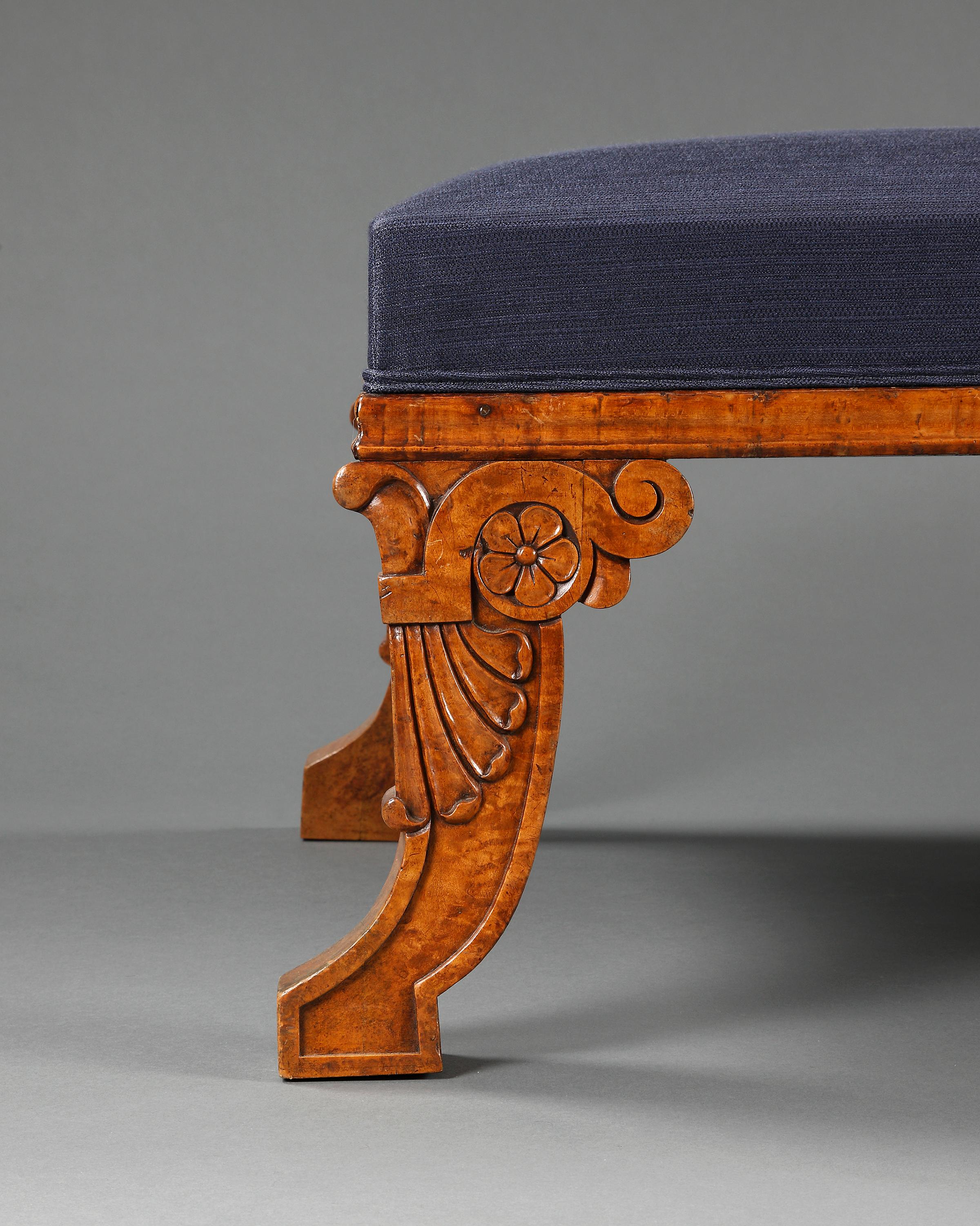 Very smart upholstered rectangular stool in the style of Thomas Hope. Raised on four shaped carved legs in solid amboyna. English, 1810.