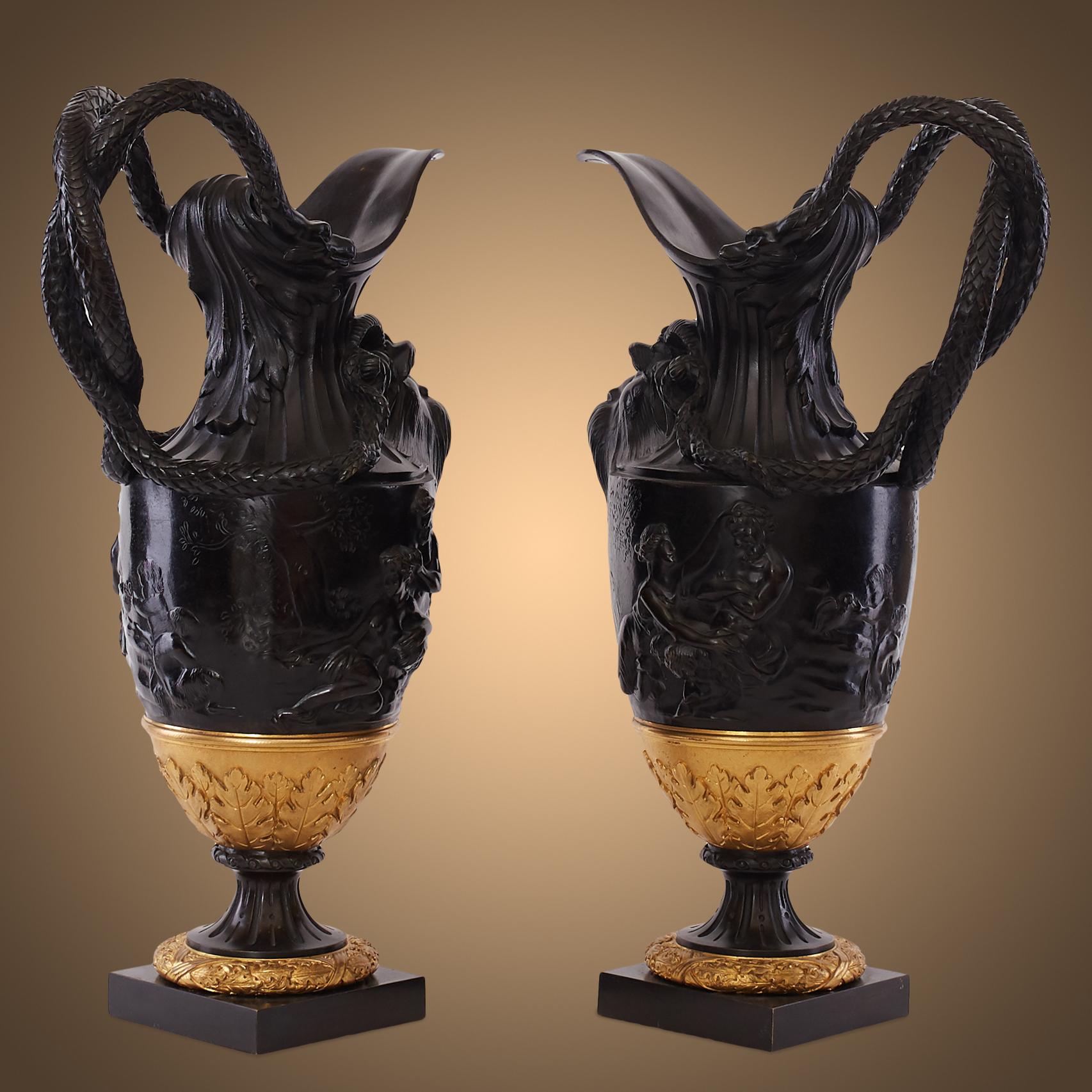 Pair of urns with fluted spreading neck fronted with a grotesque mask and a pair of entwined serpent handles, above the tapering body cast in high relief with satyrs, bacchante and putti with acanthus-cast lower section.

Claude Michael Clodion,