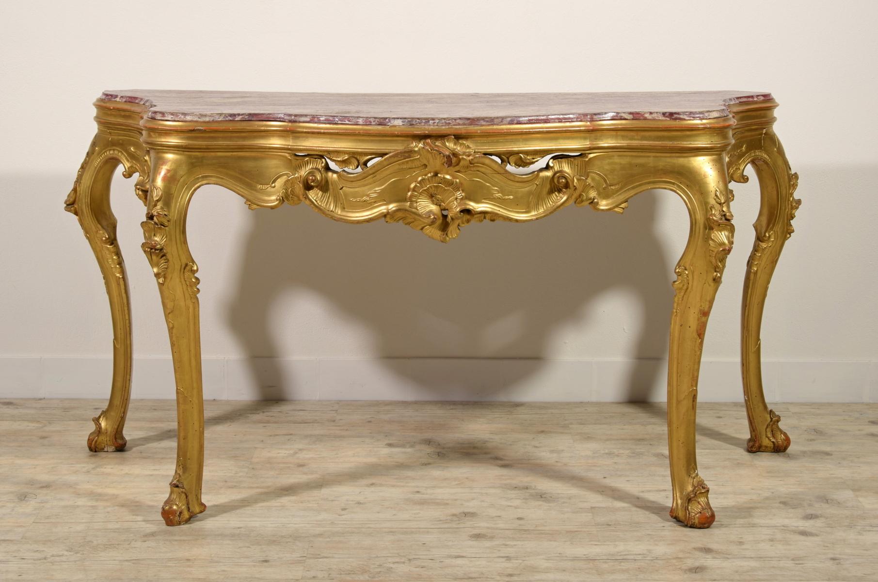 19th century, Venetian carved giltwood console table 

This console has been realized in the 19th century in Venice, Italy, in carved and gilded wood. The plan, recessed, is in wood painted to false marble. The console, of considerable size, has a
