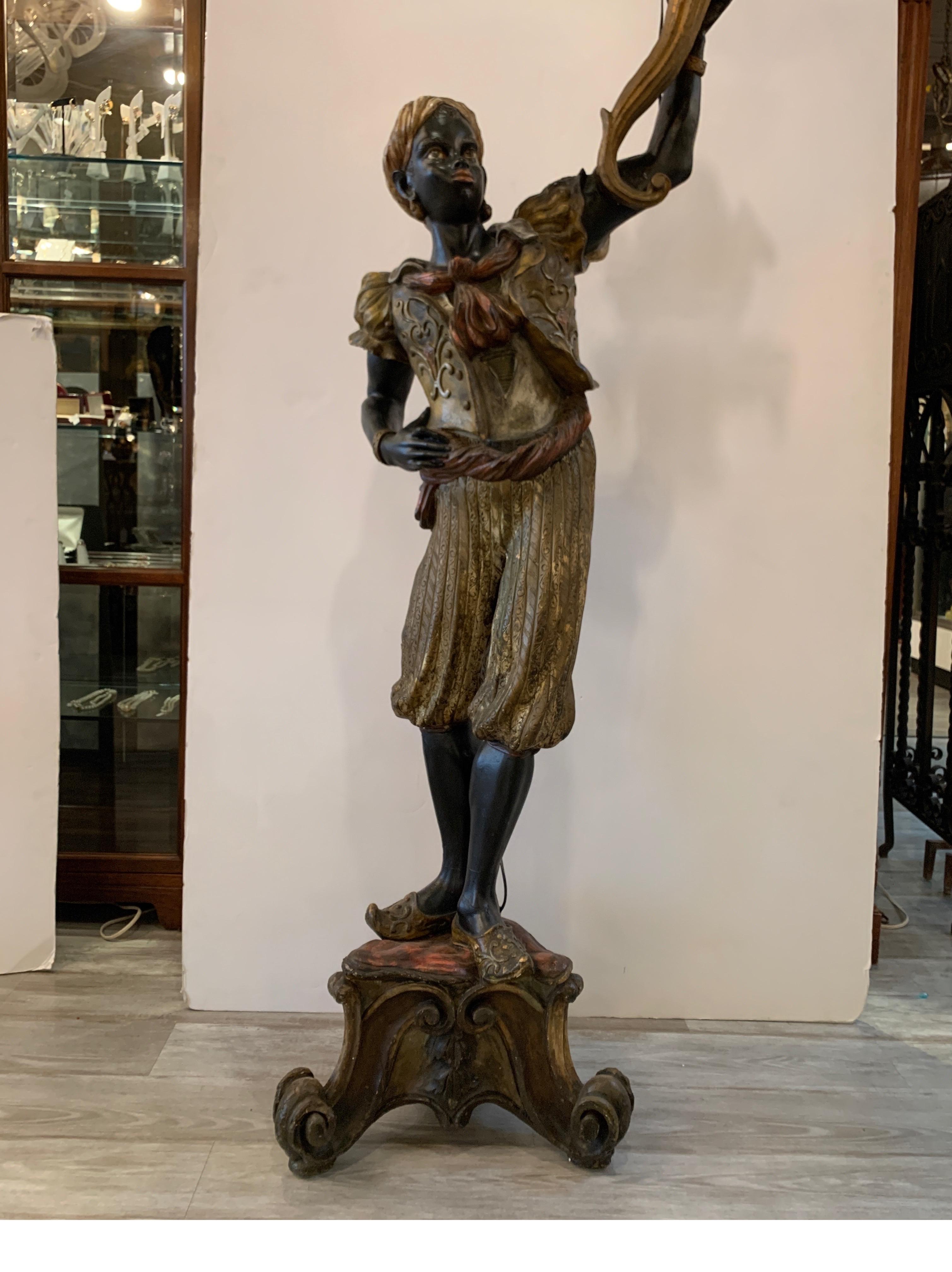 Hand carved Italian sculpture floor lamp circa 1860. The hand painted figure of a man holding up a torch light . The figure with gilt decoration all-over, circa 1860 with minor chipping and age related wear. Total height 82, height of the figure is