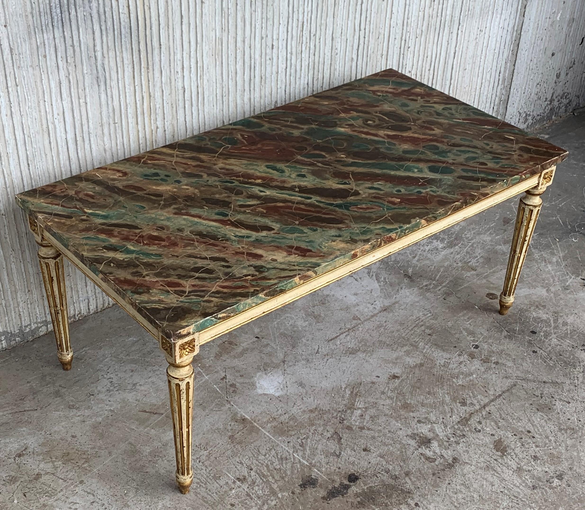 Ultra 'old world' sophistication radiates from this magnificent light green painted and parcel gilt rectangular coffee table. The table has a faux marble top over a gilt-embossed frieze and supported by square tapering legs with a similar motif. The