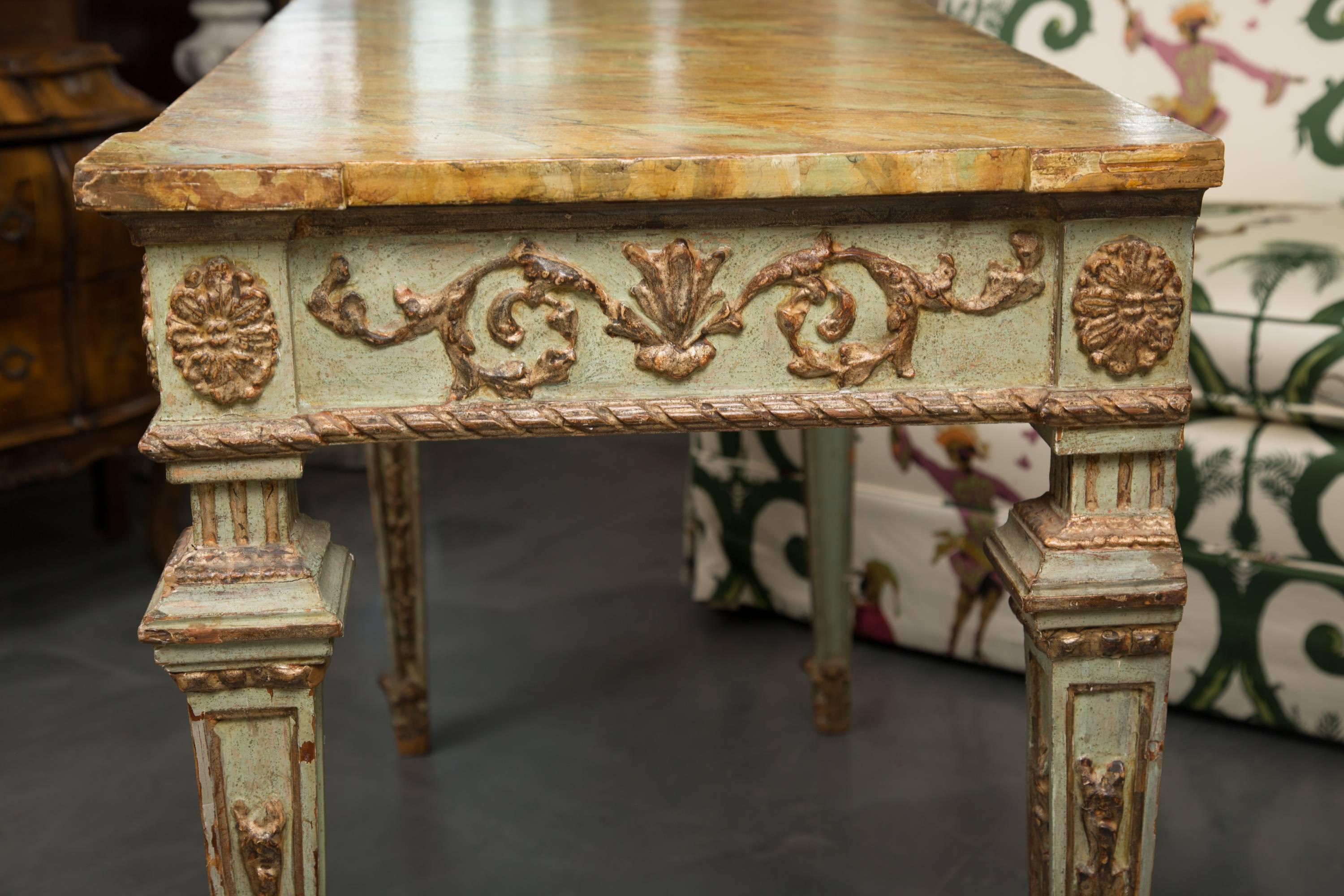 Ultra 'old world' sophistication radiates from this magnificent light green painted and parcel gilt rectangular console table. The table has a faux marble top over a gilt-embossed freize and supported by square tapering legs with a similar motif.