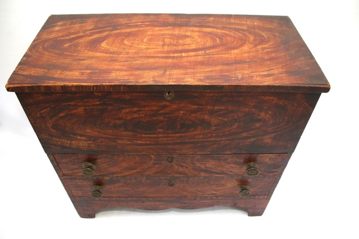 19th century Vermont grain painted blanket chest, featuring a rectangular lift-top with a deep storage compartment above two long-drawers retaining old brass hardware. The chest is raised on distinctive stylized cutout bracket feet.

New England,