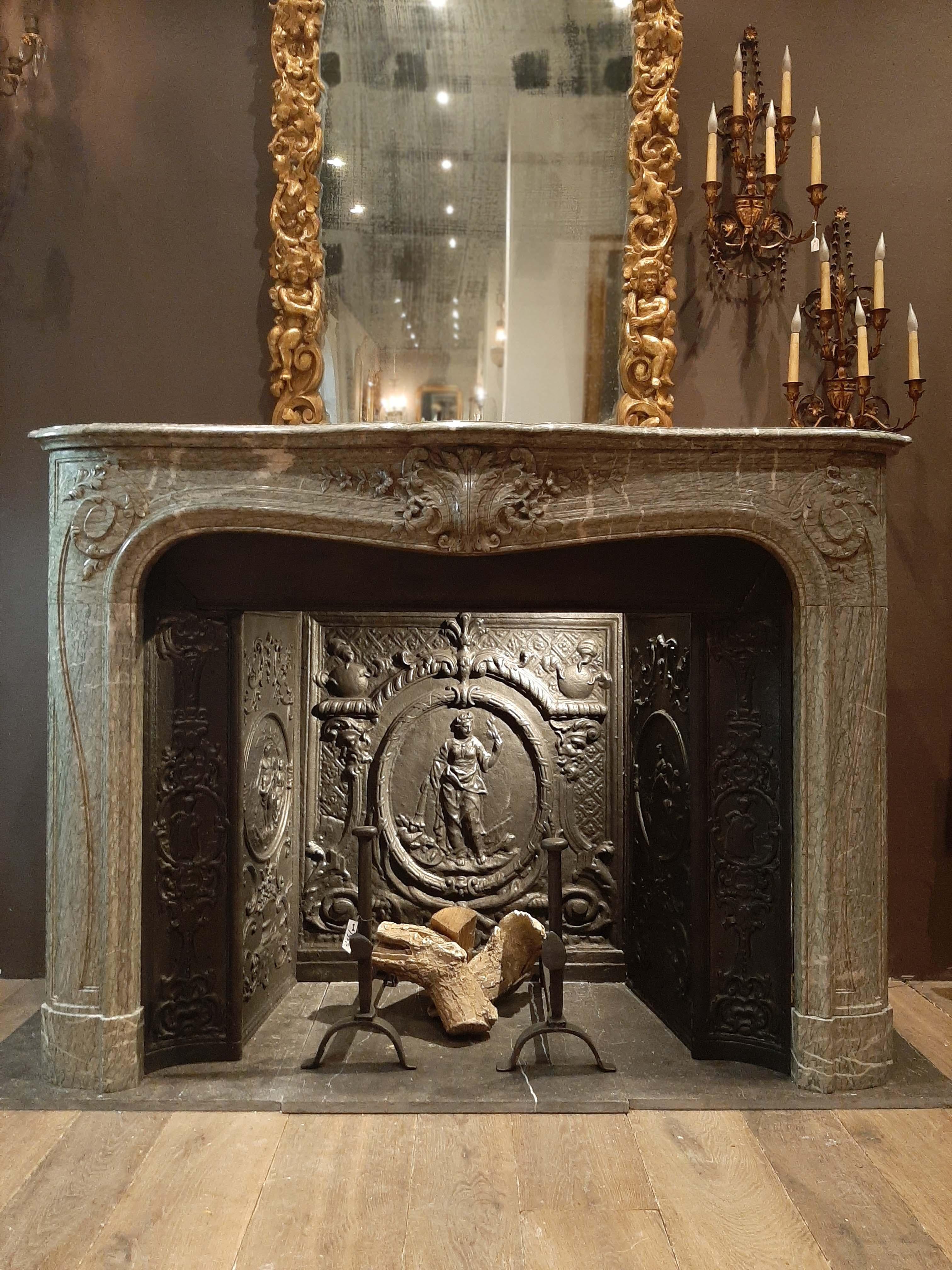 Late 19th century fireplace of stunning Vert d'Estours marble, in the style of French Baroque. This is a return fireplace and comes with a complete beautifully decorated cast iron fireplace insert, the hearth and firemount are perfectly