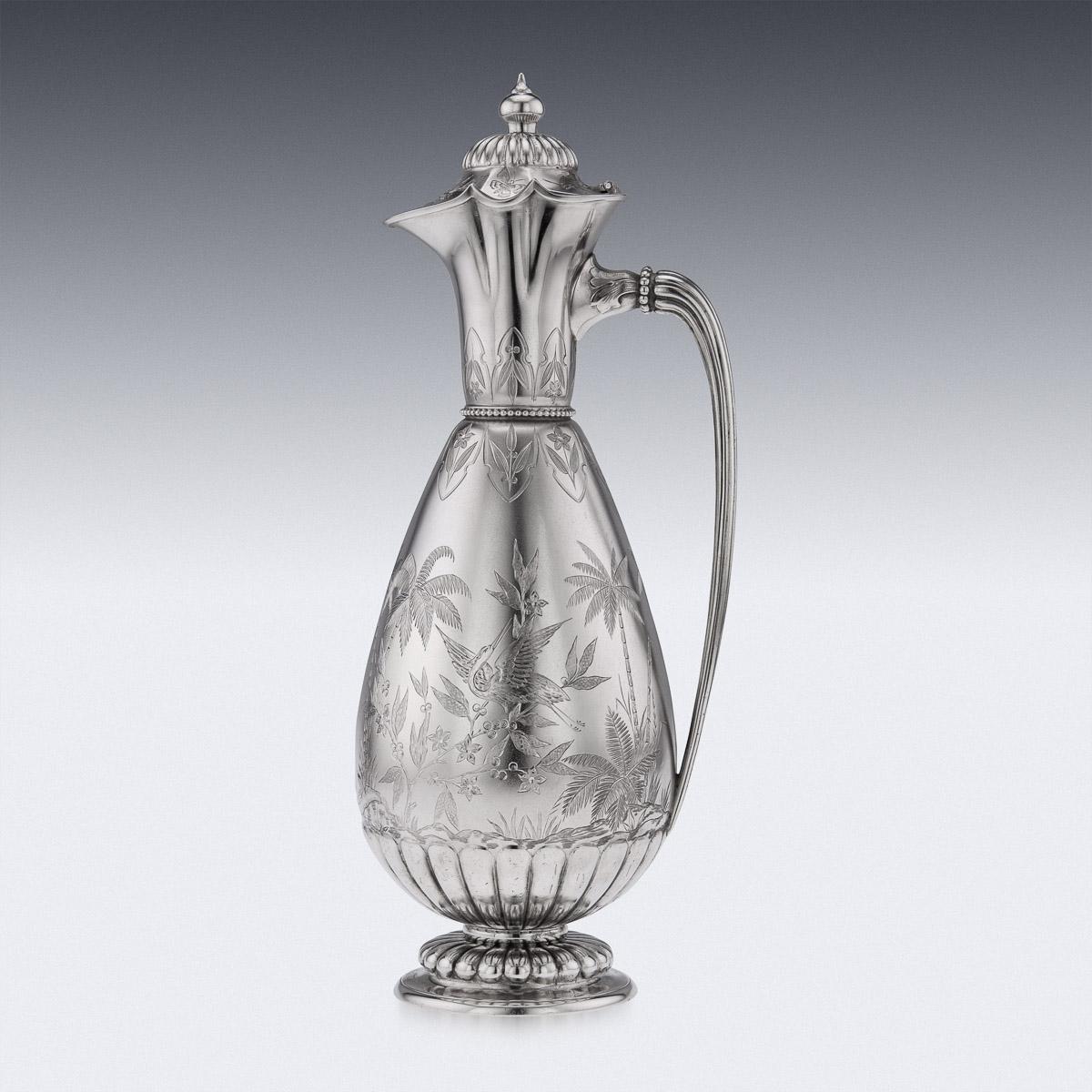19th Century Victorian Aesthetic movement silver lidded wine jug, the bulbous body beautifully hand engraved with chinoiserie scenes, bamboo trees and exotic birds, the neck decorated with leaf decoration, body mounted with a shaped handle and a
