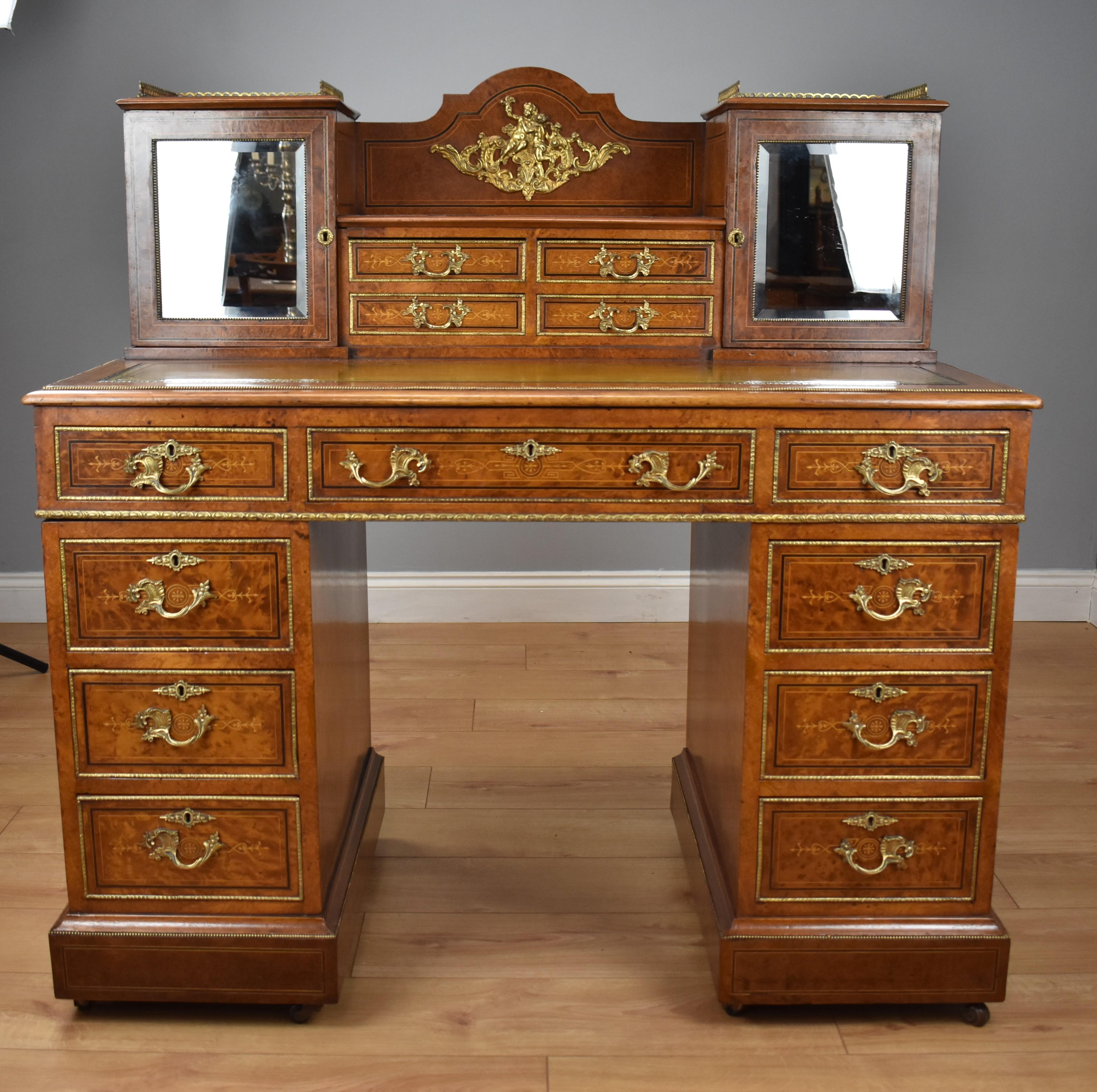 For sale is a fine quality English 19th century Victorian Amboyna Pedestal Desk. The desk top, having a superstructure with two cupboards with brass gallery tops, each panelled with a bevelled mirror, opening to reveal an interior fitted with four