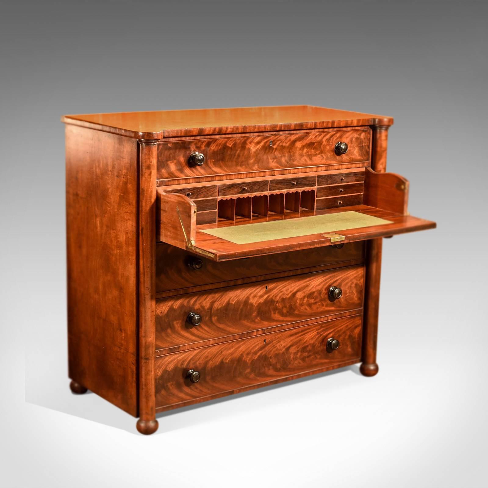 This is an antique secretaire chest of drawers dating to the Victorian era, circa 1850.

Displaying the most wonderful grain detail in flame mahogany, the drawers are finished with exceptional cock beading, dressed with ebony pulls, fitted with