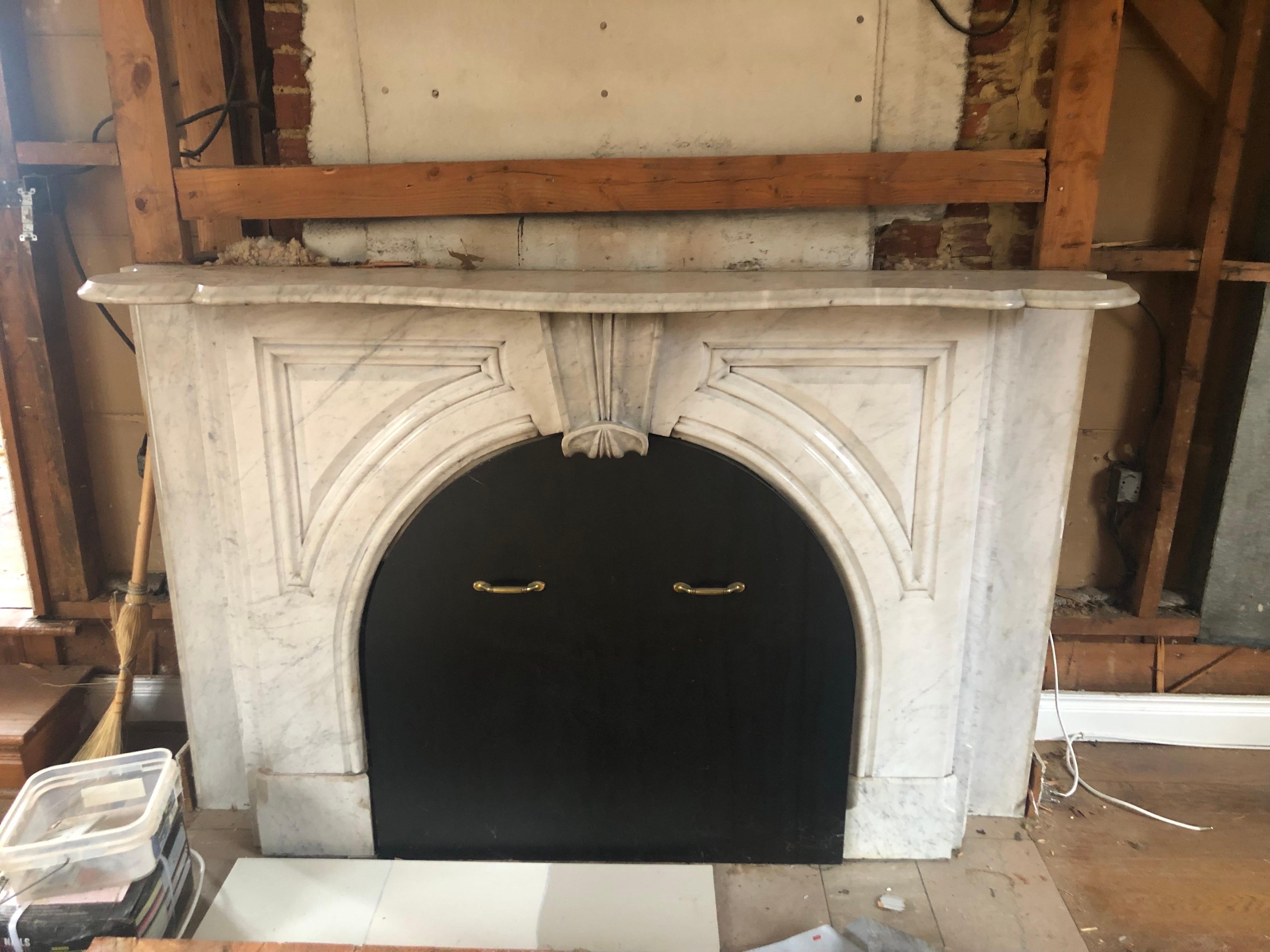 19th Century Victorian Arched Carrara marble mantel
A handsome arched mantel made of carrara marble with a center arch atopped by a scroll corbel keystone and beveled triangular detailing on either side. A lovely curved and beveled shelf to top.
