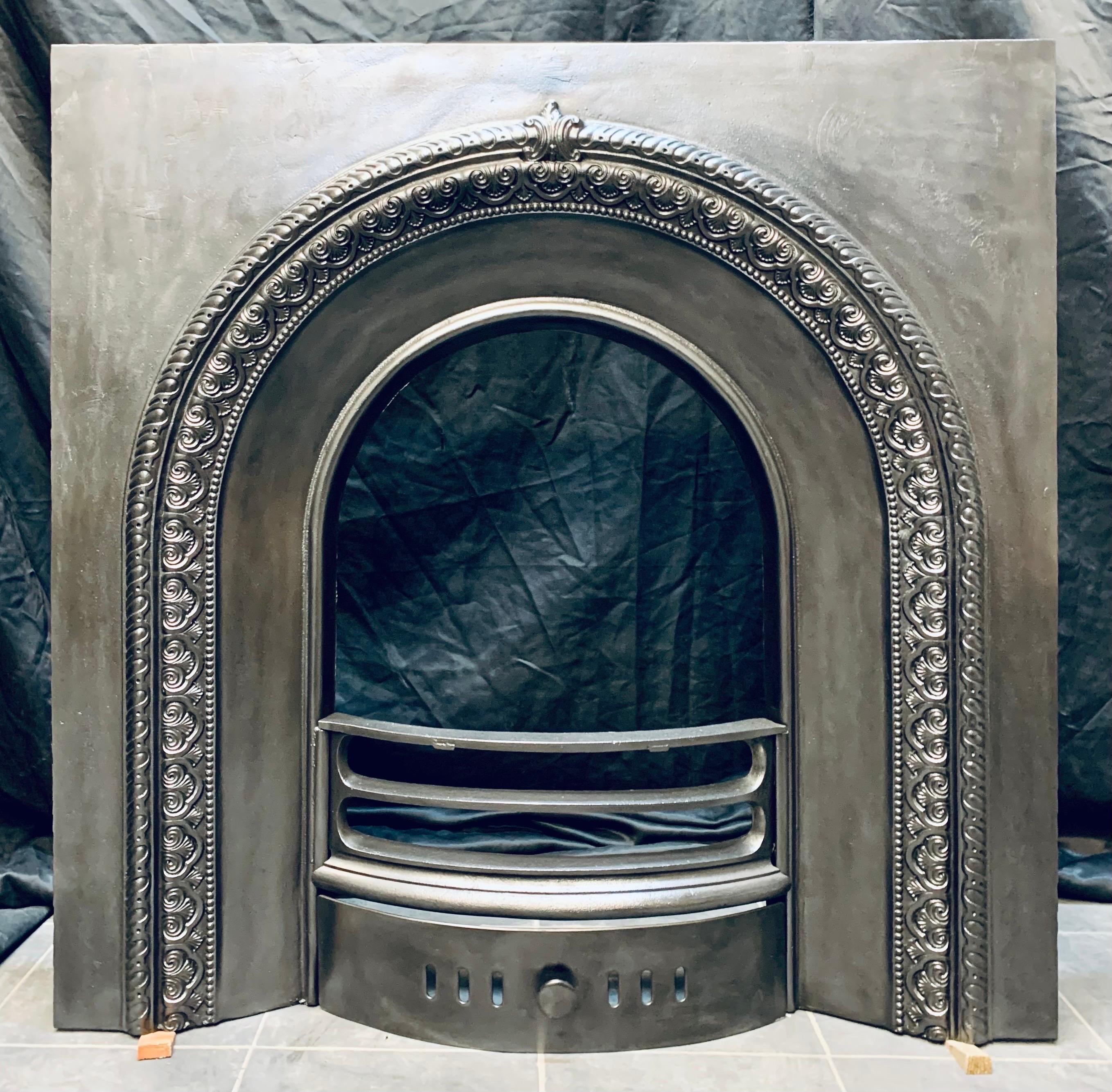 A 19th Century Victorian cast iron fireplace insert. A generous outer plate, with a raised mould arched border, and a central cartouche, a set of carved three barred fire bars, with ash pan door below. 

Scottish 1880c
Arch opening: 400mm wide x