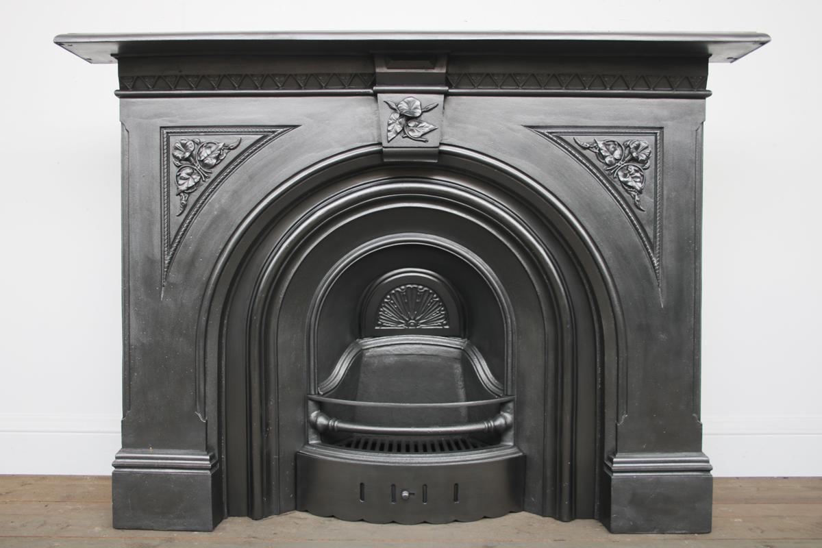 A restored 19th century mid Victorian cast iron arched fire surround with bold floral detail to the spandrels and keystone

Finished in traditional black grate polish and pictured with an original arched grate, sold separately.

For detailed