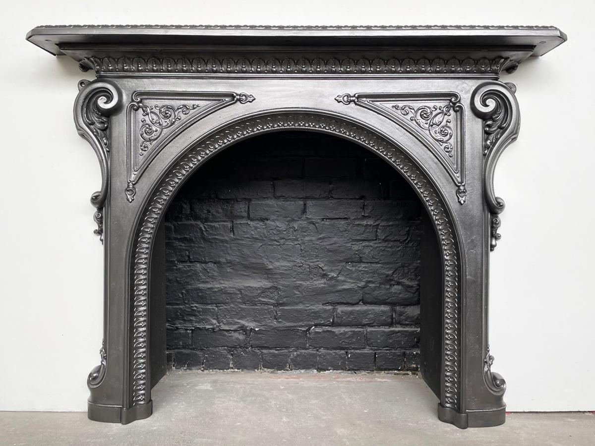 An ornate antique 19th century mid Victorian cast iron fireplace surround, with an arched aperture. Circa 1870.

Restored and finished with traditional black grate polish.

For detailed sizes please see the size diagram in the image gallery.