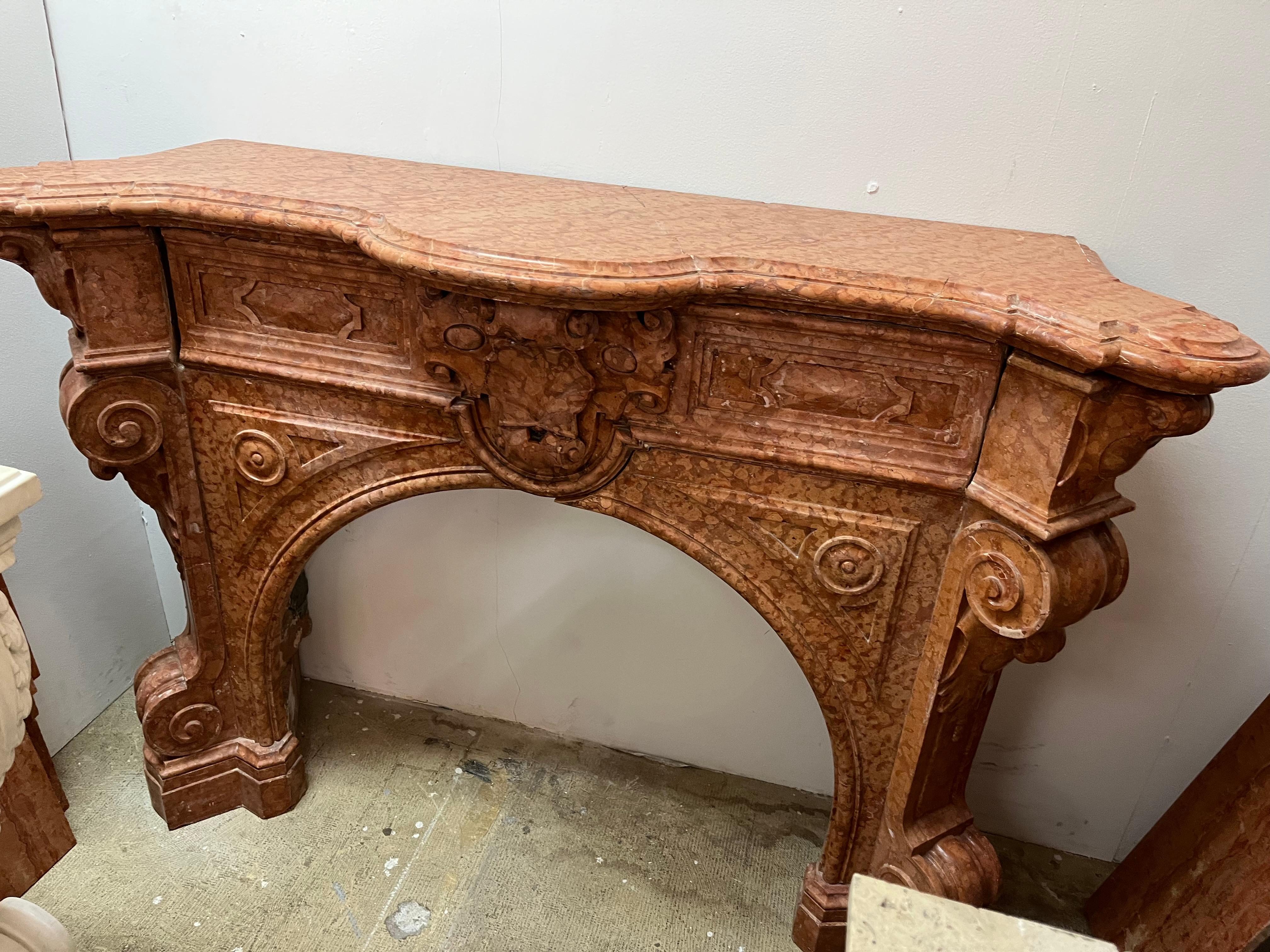 Victorian hand carved mantle in Sienna marble color with arched firebox.