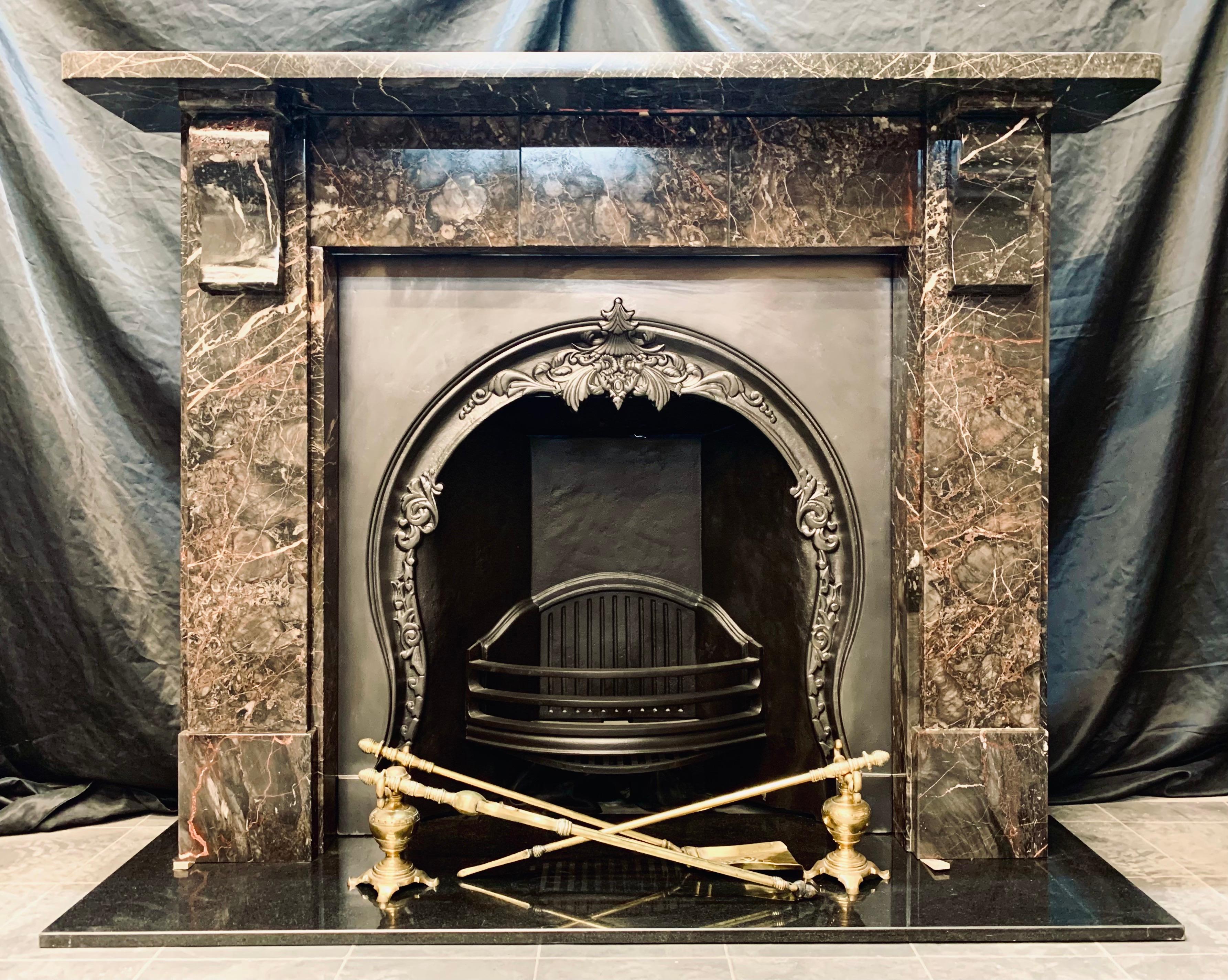 A well balanced 19th century Victorian fireplace surround in richly veined Devonshire Ashburton marble. A substantial top shelf sits directly above an unadorned frieze with a stepped central tablet. Flanked by stepped jambs each displaying a
