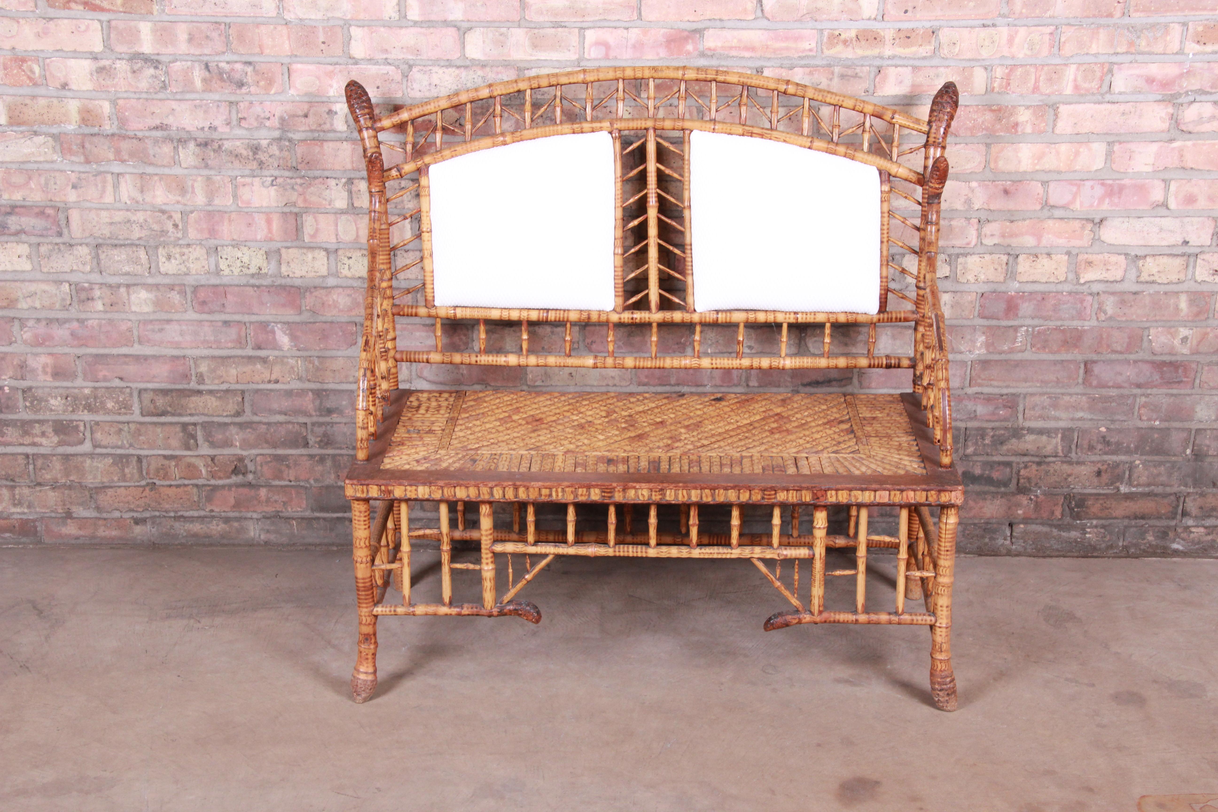 A stunning antique Victorian settee or love seat

USA, 19th century

Bamboo and hardwood, with newer upholstered back panels.

Measures: 42.75