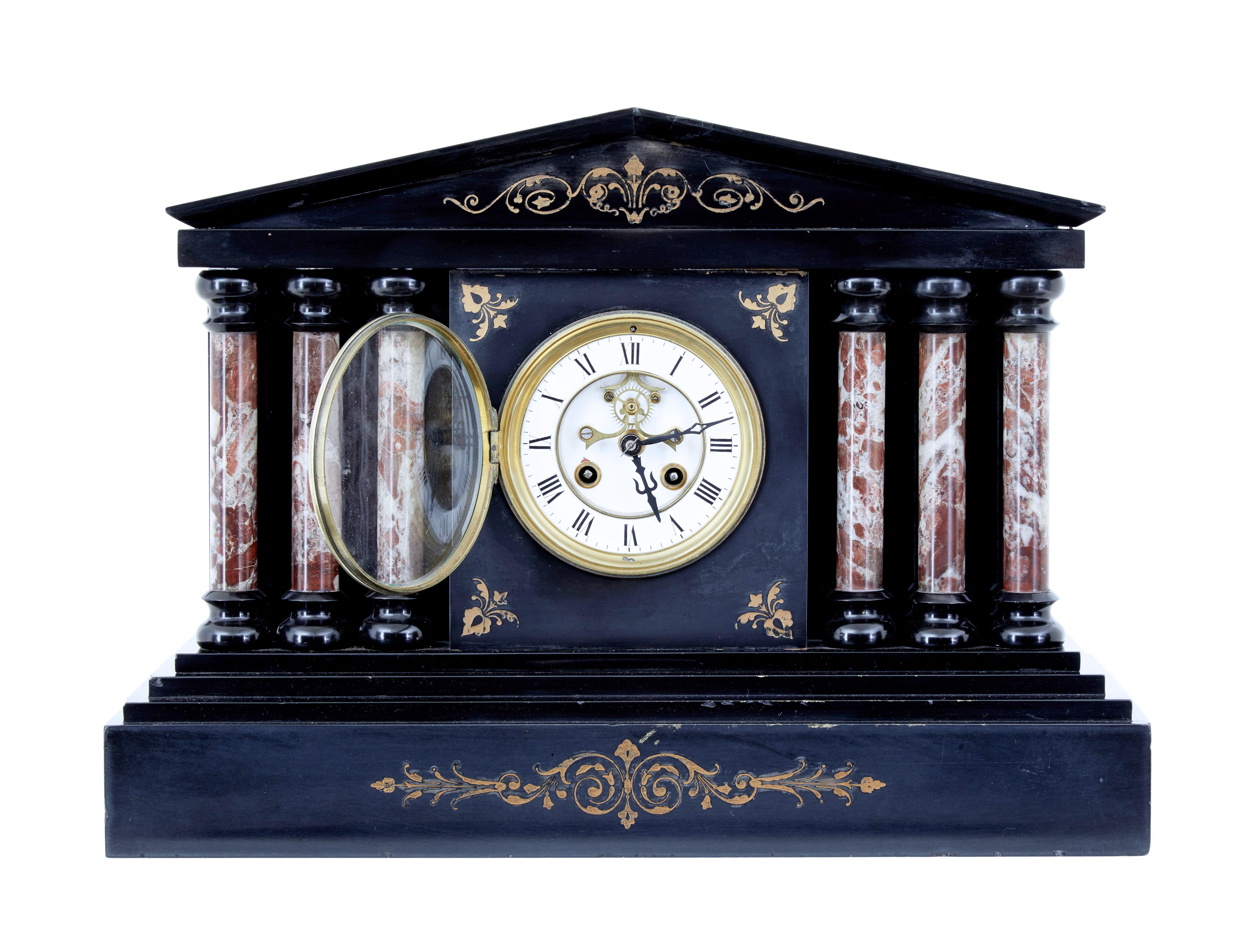 19th century Victorian black marble mantle clock circa 1890.

Victorian mourning clock made in black marble. Pointed architectural pediment with gold leaf swag design below. White enamel face with roman numerals.

Clock face is flanked either