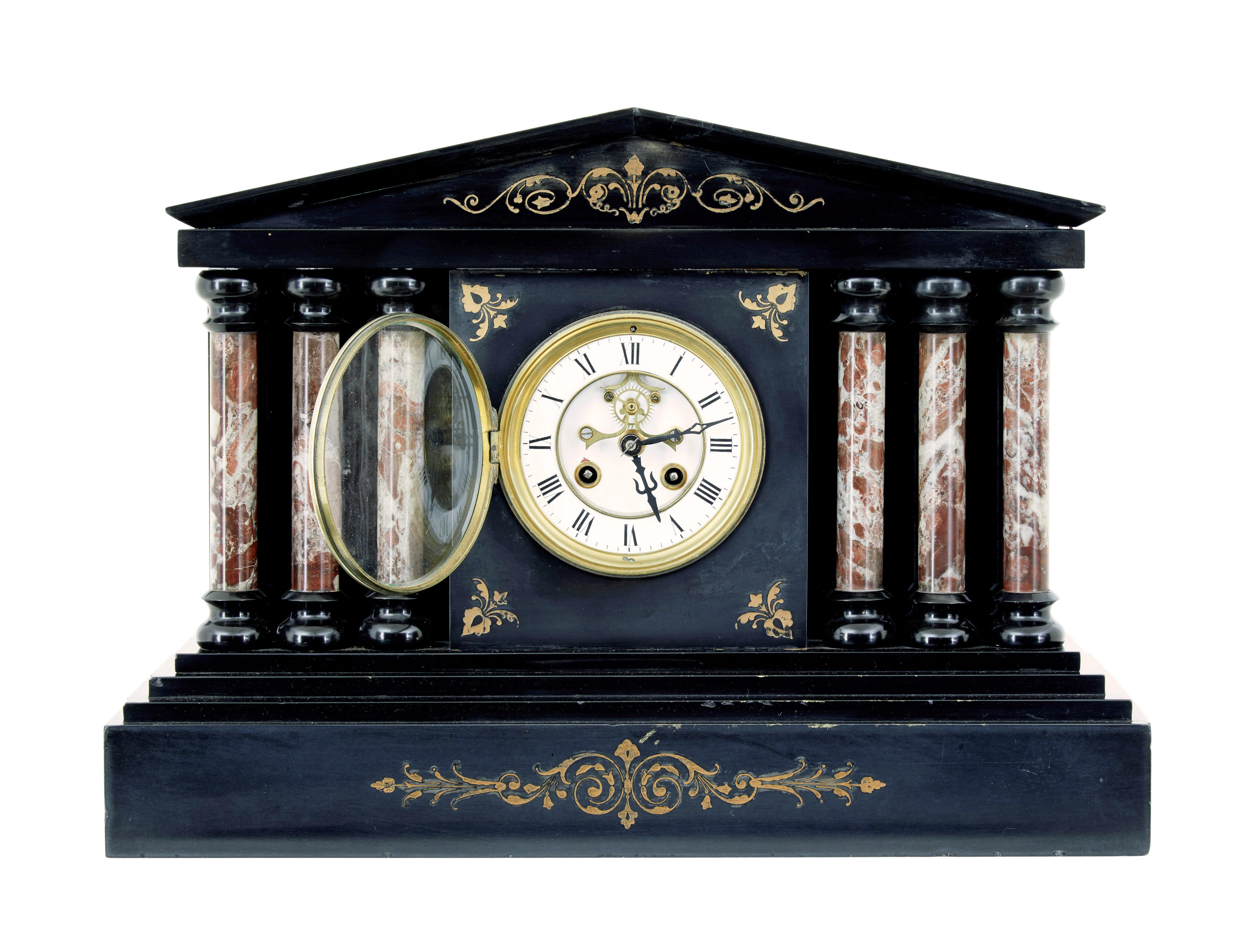 19th century victorian black marble mantle clock circa 1890.

Victorian mourning clock made in black marble.  Pointed architectural pediment with gold leaf swag design below.  White enamel face with roman numerals.

Clock face is flanked either side