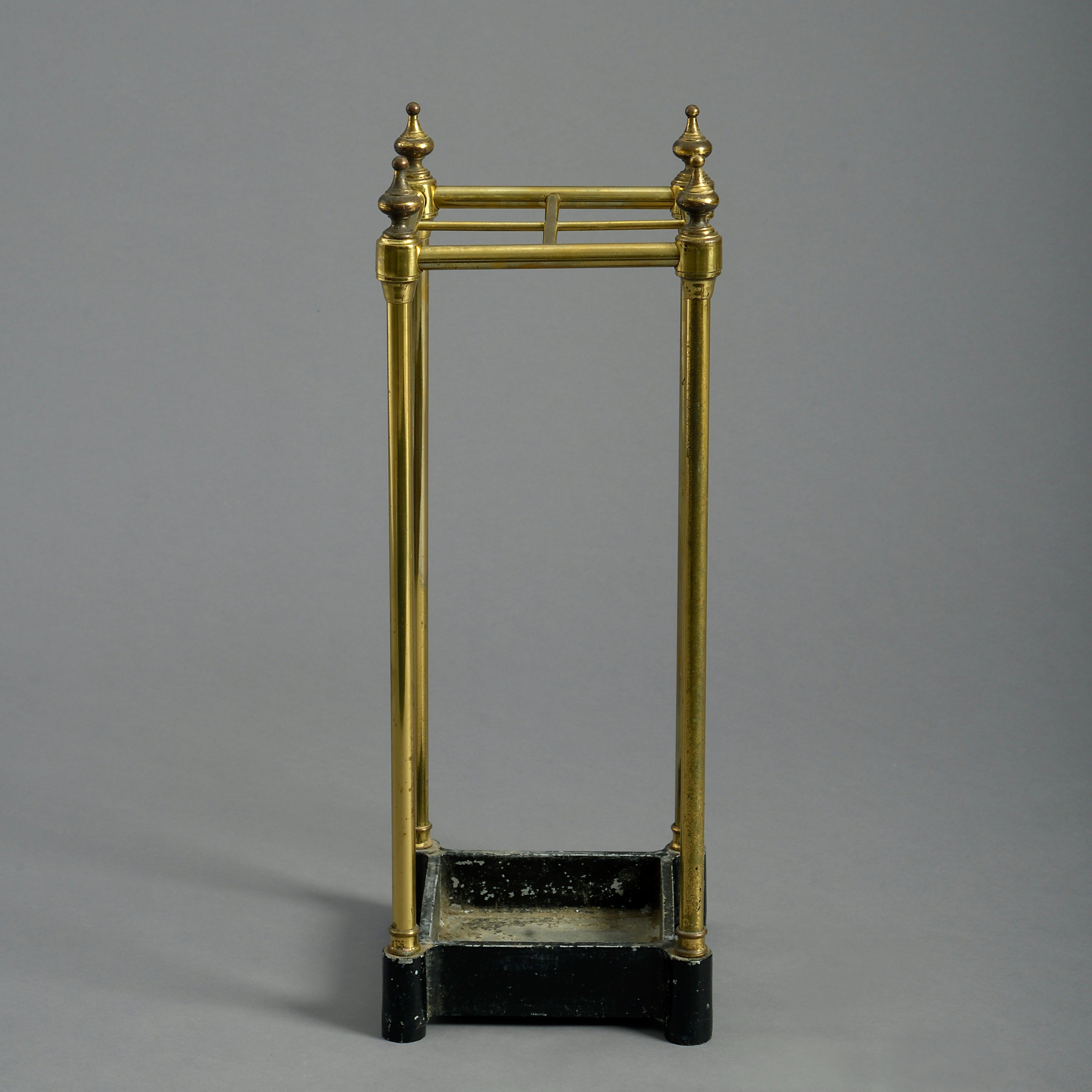 A mid-nineteenth century Victorian Period brass stick and umbrella stand with turned finials upon four dividers, supported upon a tubular frame and set on a black painted cast iron drip tray.
