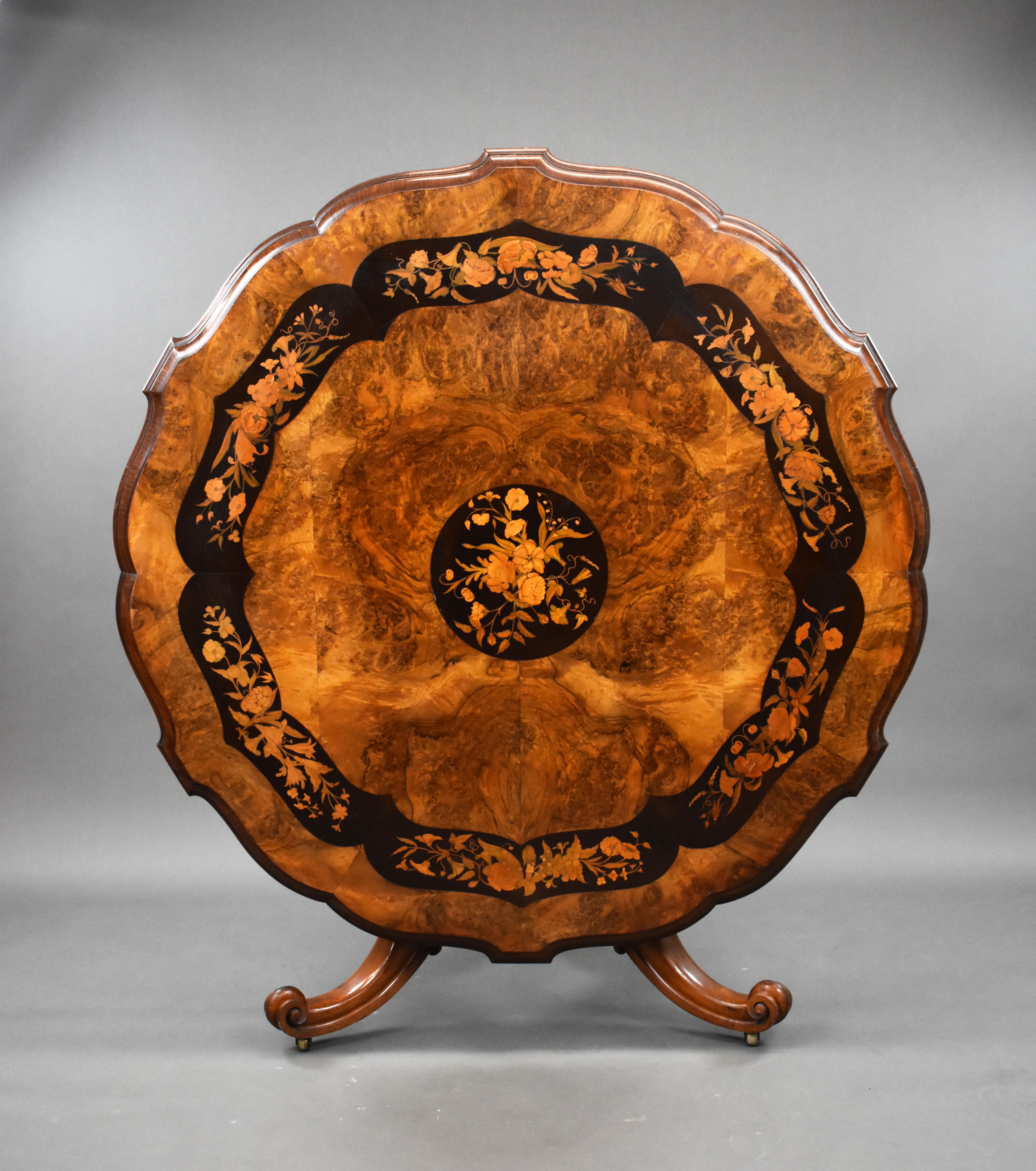 For sale is a top quality Victorian burr walnut and marquetry centre table. The table top is ornately shaped and decorated with very fine floral marquetry inlay. This is above a marquetry inlaid base, standing on three shaped and carved legs
