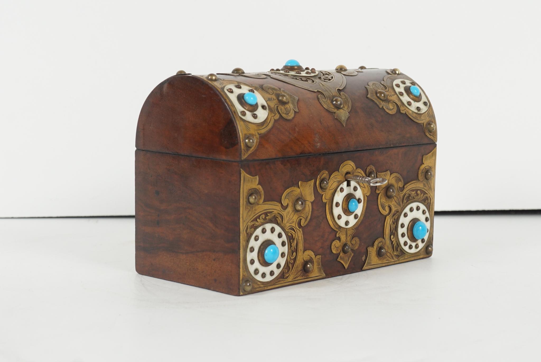 This fine old English box made circa 1850-1860 is made from burled walnut with dramatic figuring. The box is then mounted with gilded bronze and engraved mounts set with bone discs and further enhanced with turquoise glass jewels. The box retains