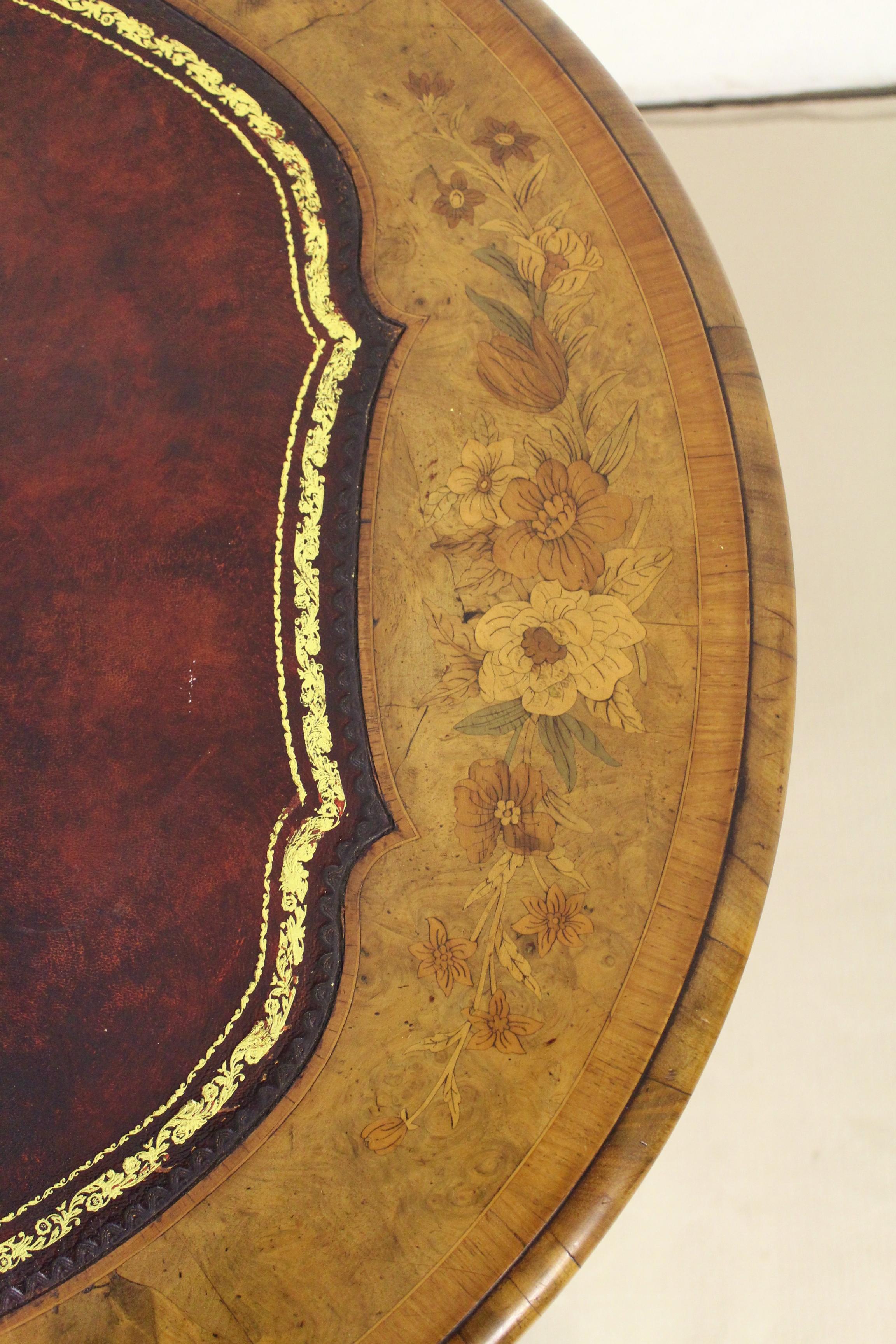 A wonderful and rare Victorian oval shaped burr walnut writing table. Of generous proportions and well made in walnut with attractive burr walnut veneers. The oval top is fitted with a sumptuous burgundy leather writing surface and is decorated with